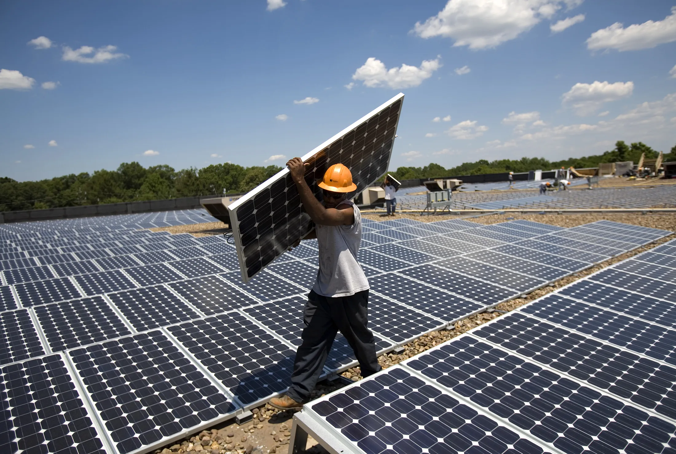 HILLSBOROUGH - JULY 15: Employees of SunEdison install photo voltaic solar panels on the roof of a Kohl's Department Store in Hillsborough, New Jersey July 15, 2008. Company engineers estimate Kohl's will be able to reduce their electricity usage on average by 25% once power begins flowing from the 1980 rooftop panels. Kohl's signed a contract with SunEdison, based in Beltsville, Maryland, to receive electricity for 20 years at a reduced price from public utility rates. New Jersey is the nation's second largest producer of solar energy behind California. State and federal tax incentives help individuals and commercial enterprises cover the costs of solar panel installations. SunEdison is North America's largest solar energy service provider.
