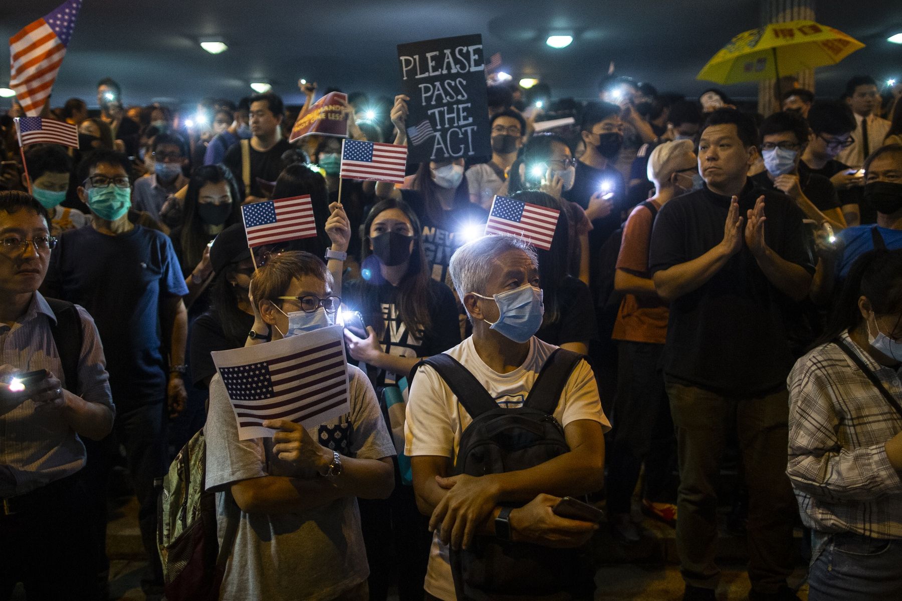 Demonstrators hold placards and the American flag during a rally in support of the Hong Kong Human Rights and Democracy Act in Hong Kong.