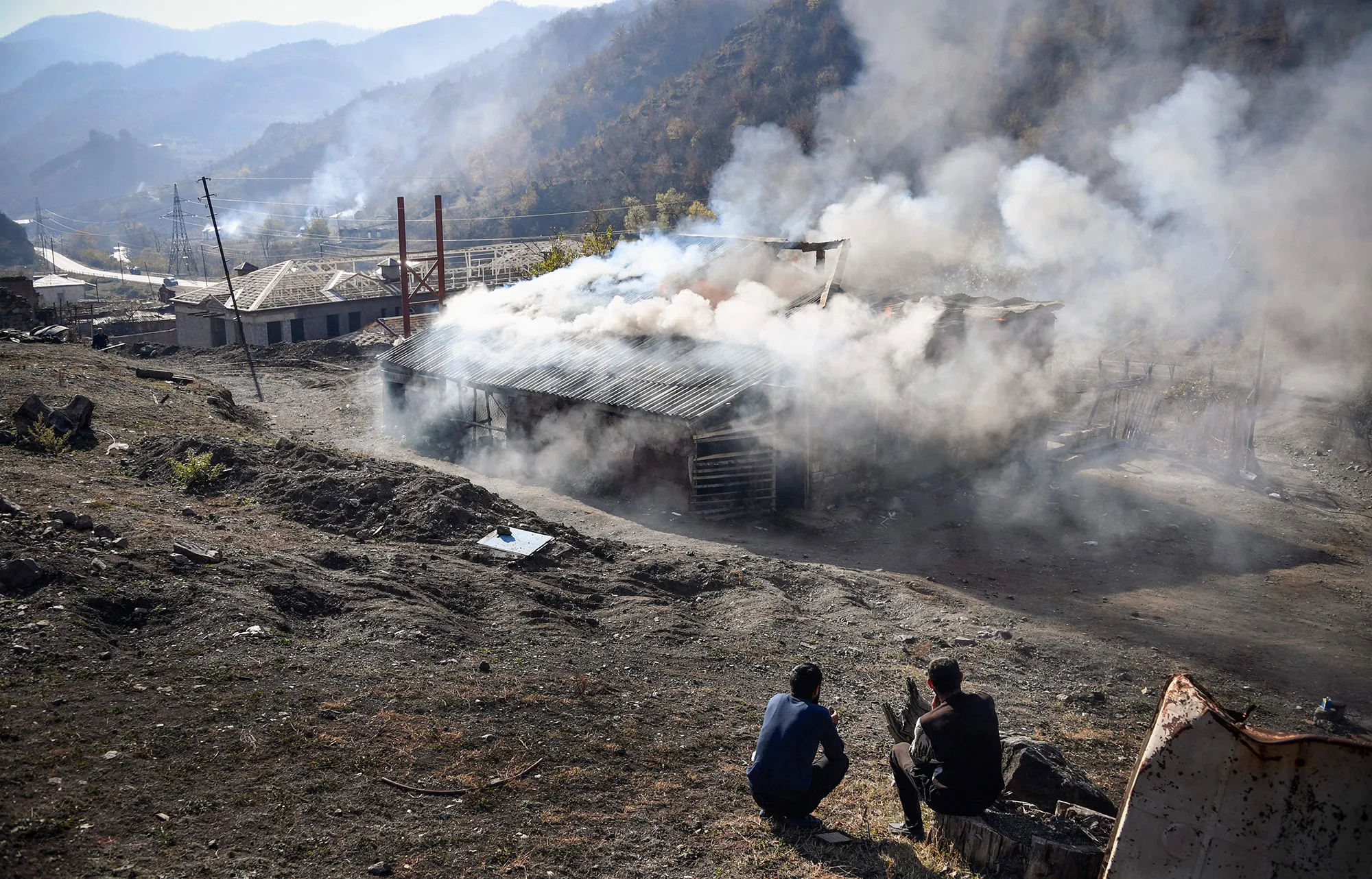 People watch a burning house outside the town of Kalbajar, during the military conflict between Armenia and Azerbaijan over the region of Nagorno-Karabakh,&nbsp;on Nov. 14, 2020.&nbsp;