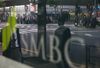 Pedestrians are reflected in the window of a Sumitomo Mitsui Banking Corp. branch, a unit of Sumitomo Mitsui Financial Group Inc. (SMFG).