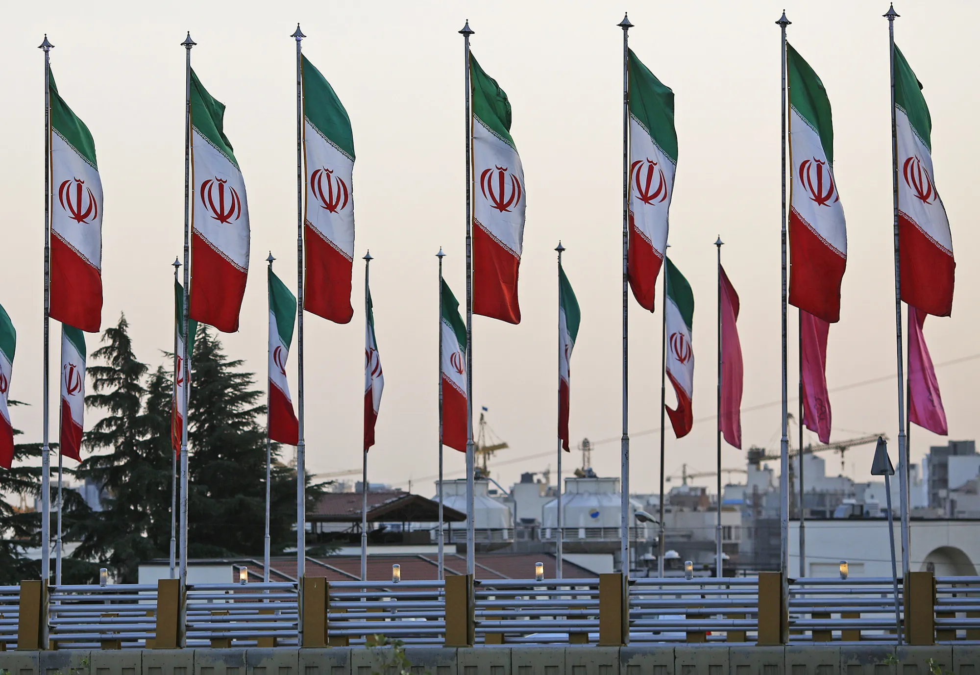 Iranian national flags fly along a highway in Tehran, Iran, on Saturday, Aug. 22, 2015. Iran plans to raise oil production 'at any cost' to defend the country's market share and backs calls for an emergency OPEC meeting to help shore up crude prices.
