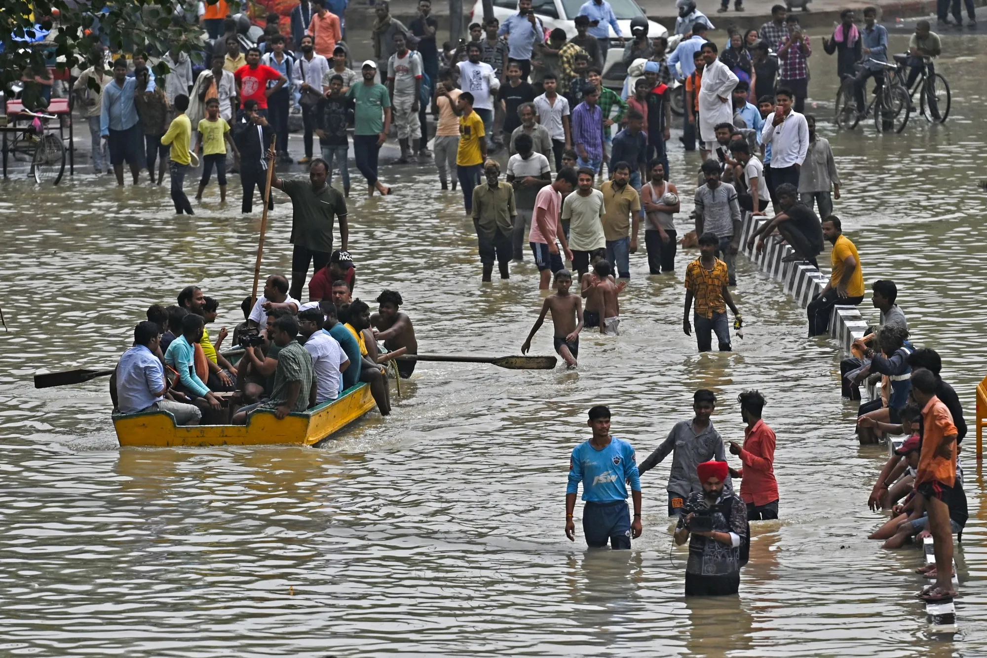 People wade through a flooded street in New Delhi on July 14.