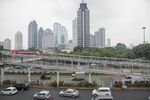 Traffic moves past buildings in the business district in Jakarta, Indonesia, on Monday, April 13, 2015. Indonesia's central bank is scheduled to announce its interest rate decision tomorrow.

