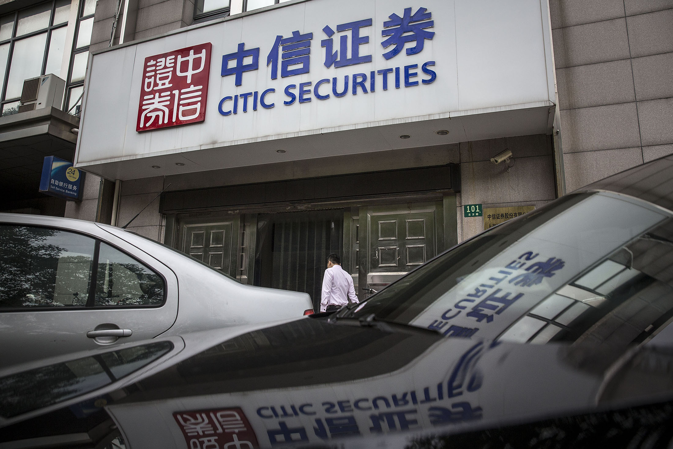 A pedestrian walks past a Citic Securities branch in Shanghai, China.

