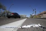 A vehicle goes by the scene of Sunday's fatality where a pedestrian was stuck by an Uber vehicle in autonomous mode, in Tempe, Arizona. 