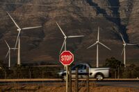 A stop sign in front of wind turbines at the Gouda wind power facility in South Africa.