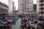 Attendees sit during a flag-raising ceremony to mark the 24th anniversary of Hong Kong's return to Chinese rule at Pui Kiu Middle School in Hong Kong.