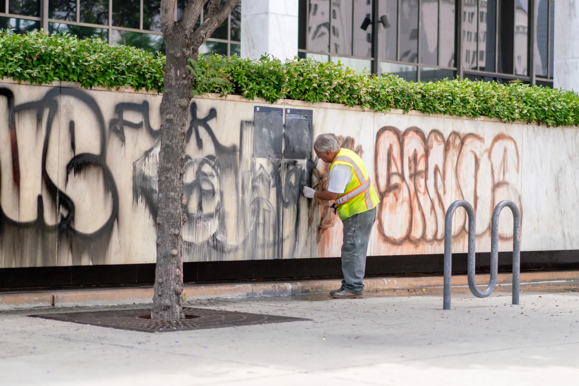 A worker cleans graffiti off the Edward R. Roybal Federal Building in Los Angeles on June 9, 2025.