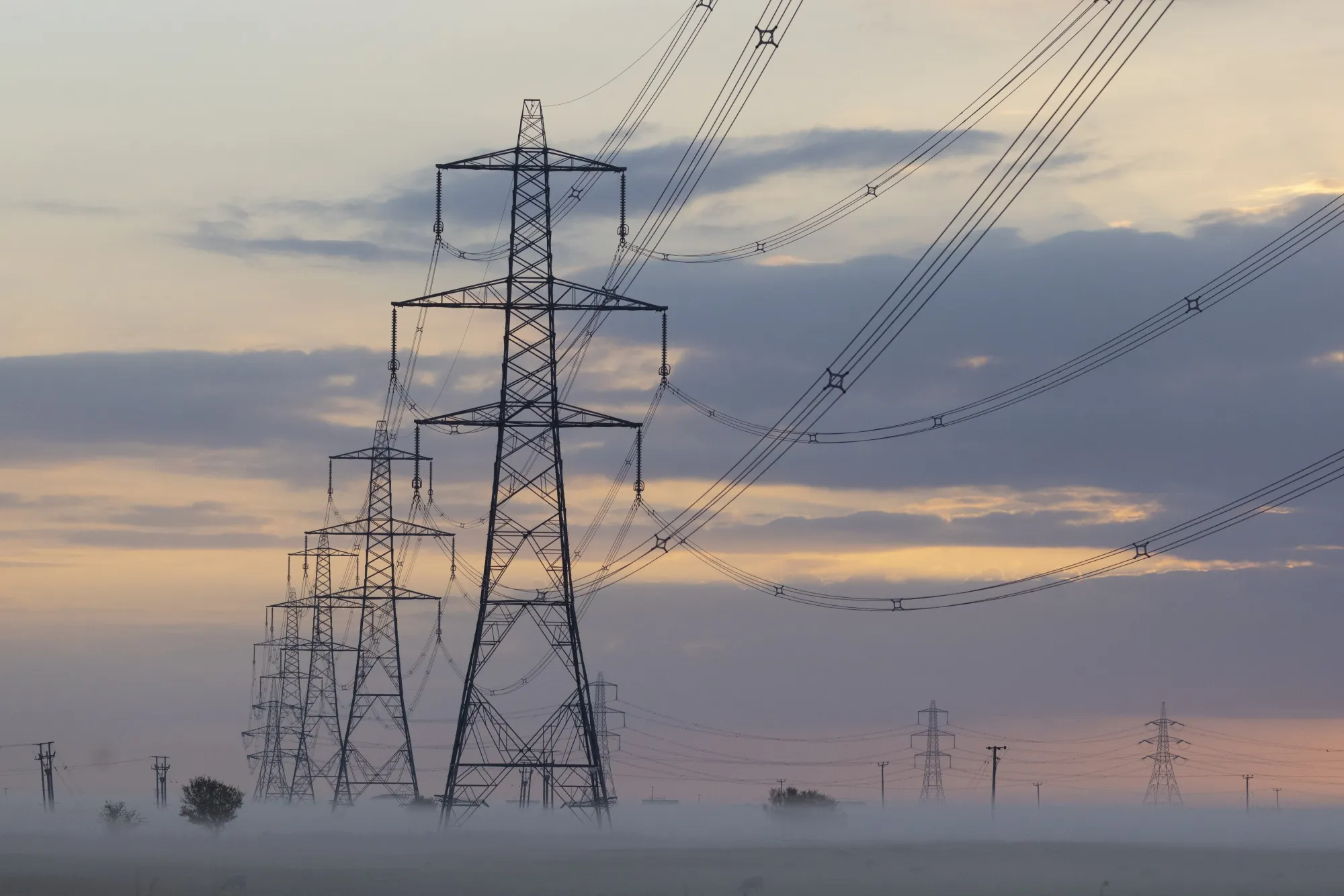 Electricity pylons and power lines in morning mist on the Isle of Grain, UK, on Monday, Aug. 22, 2022. The UK is about to receive liquefied natural gas from far-off Australia for the first time in at least six years, highlighting the European regions desperation in grappling with its worst energy crisis in decades.