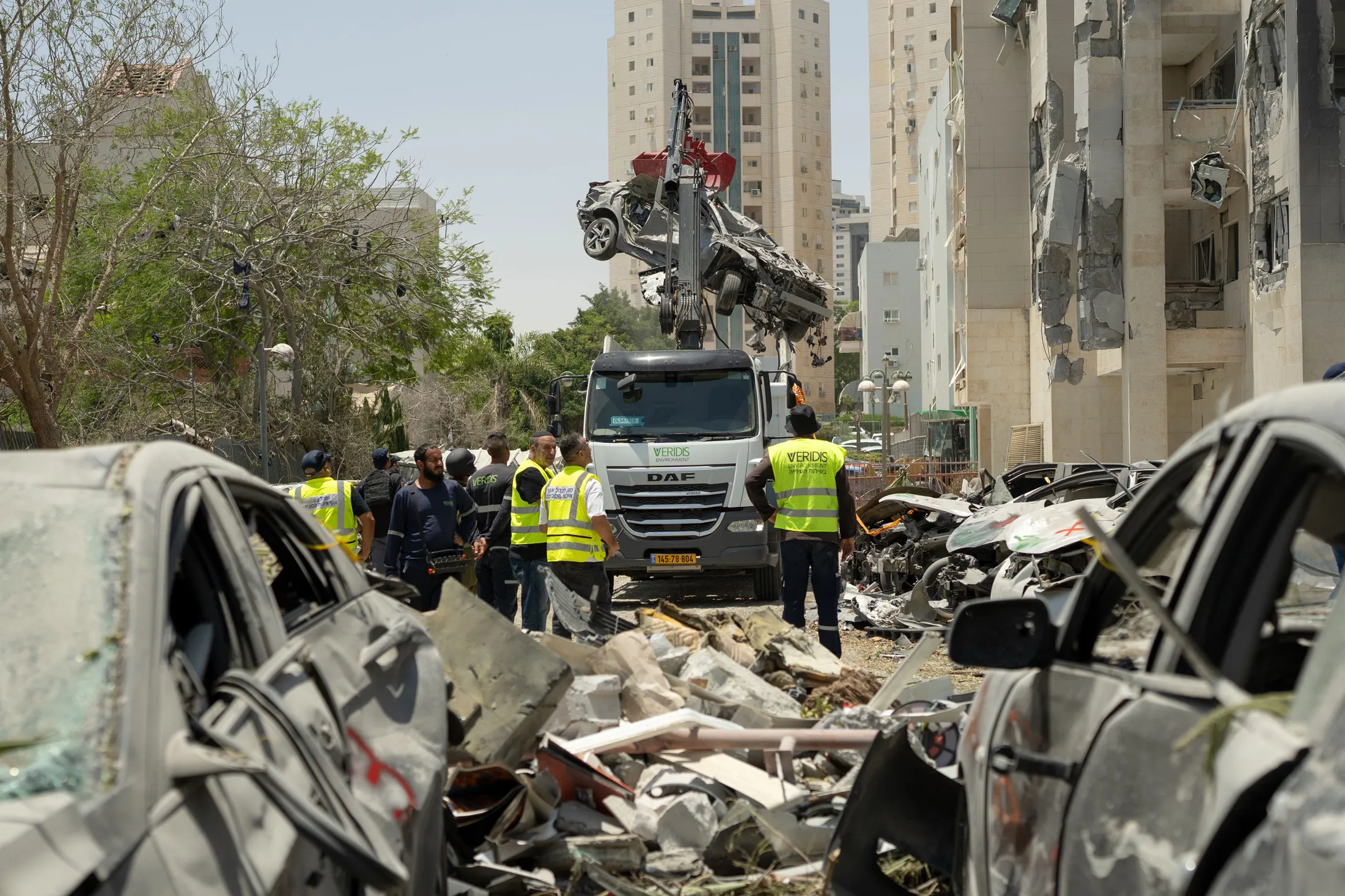 Workers clear debris at the site of an Iranian strike in Beersheba, Israel, On June 24.