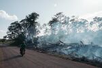 A motorcyclist observes an intentional forest fire in the jungle along a road in Oxkutzcab region, Mexico, on Feb. 18. Flaws in President Lopez Obrador’s flagship environmental project&nbsp;risk undoing its good intentions.