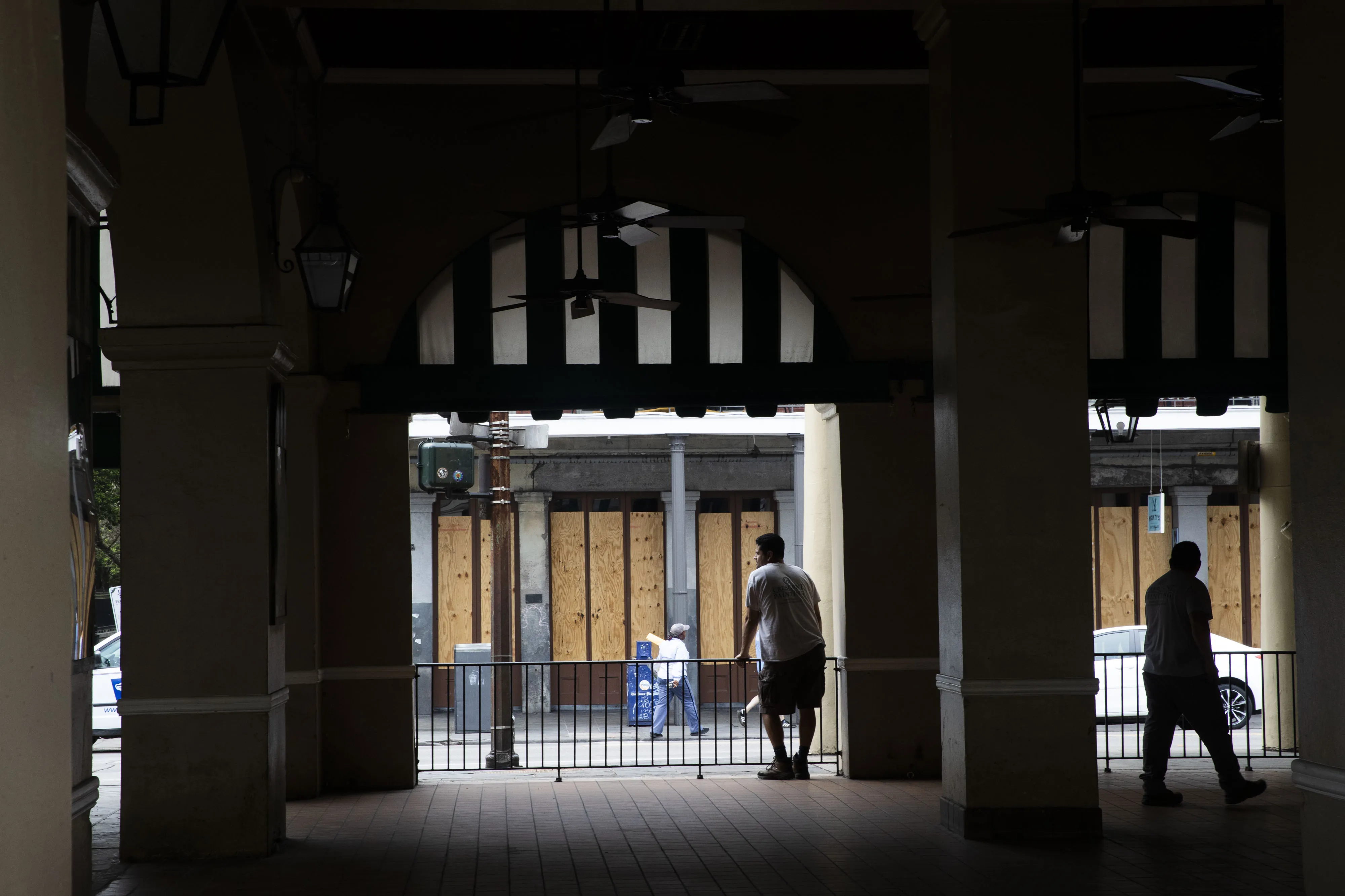 Workers stand in the outside seating area of a restaurant closed in New Orleans.
