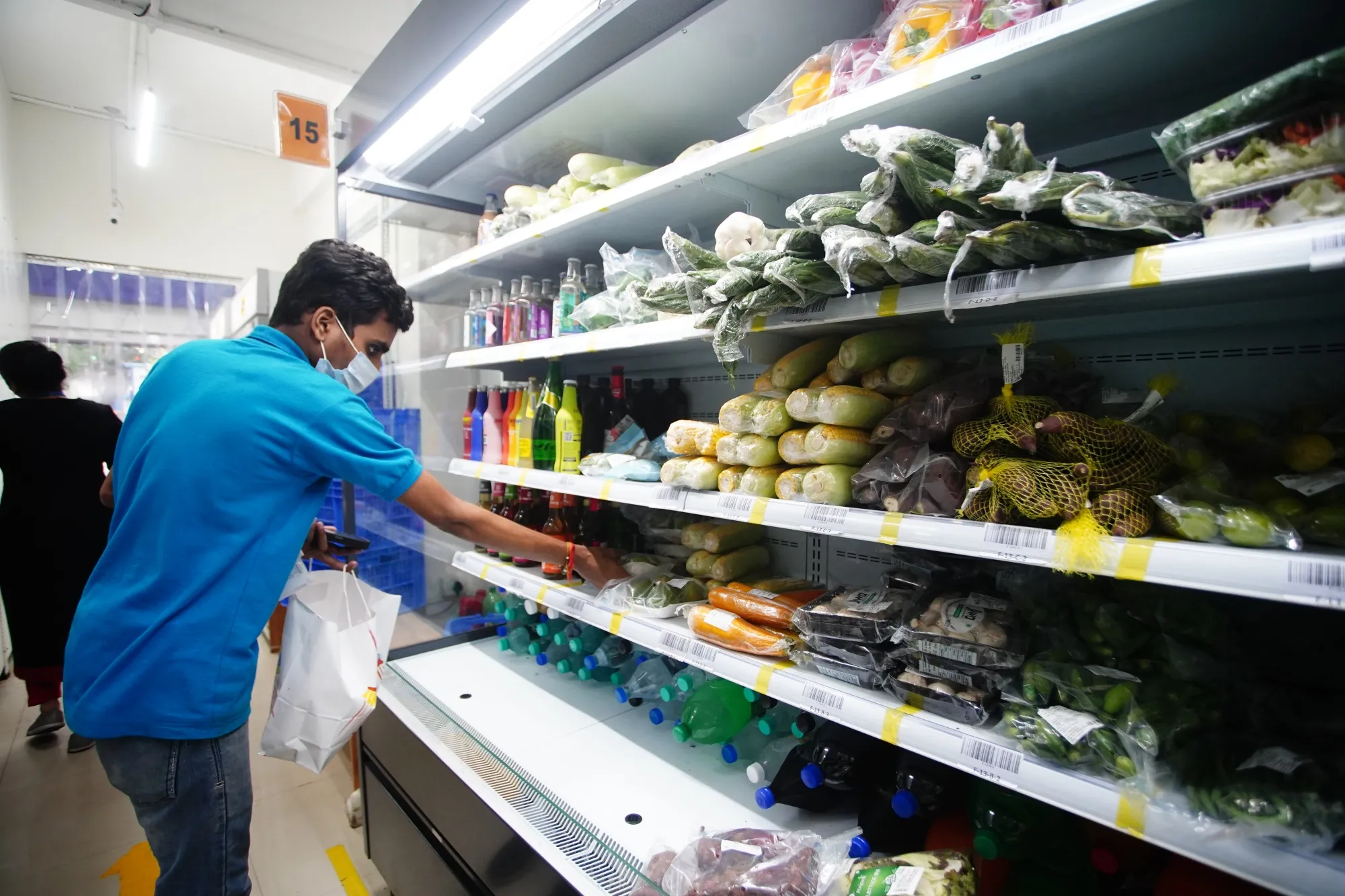 A Zepto employee selects groceries for a delivery.