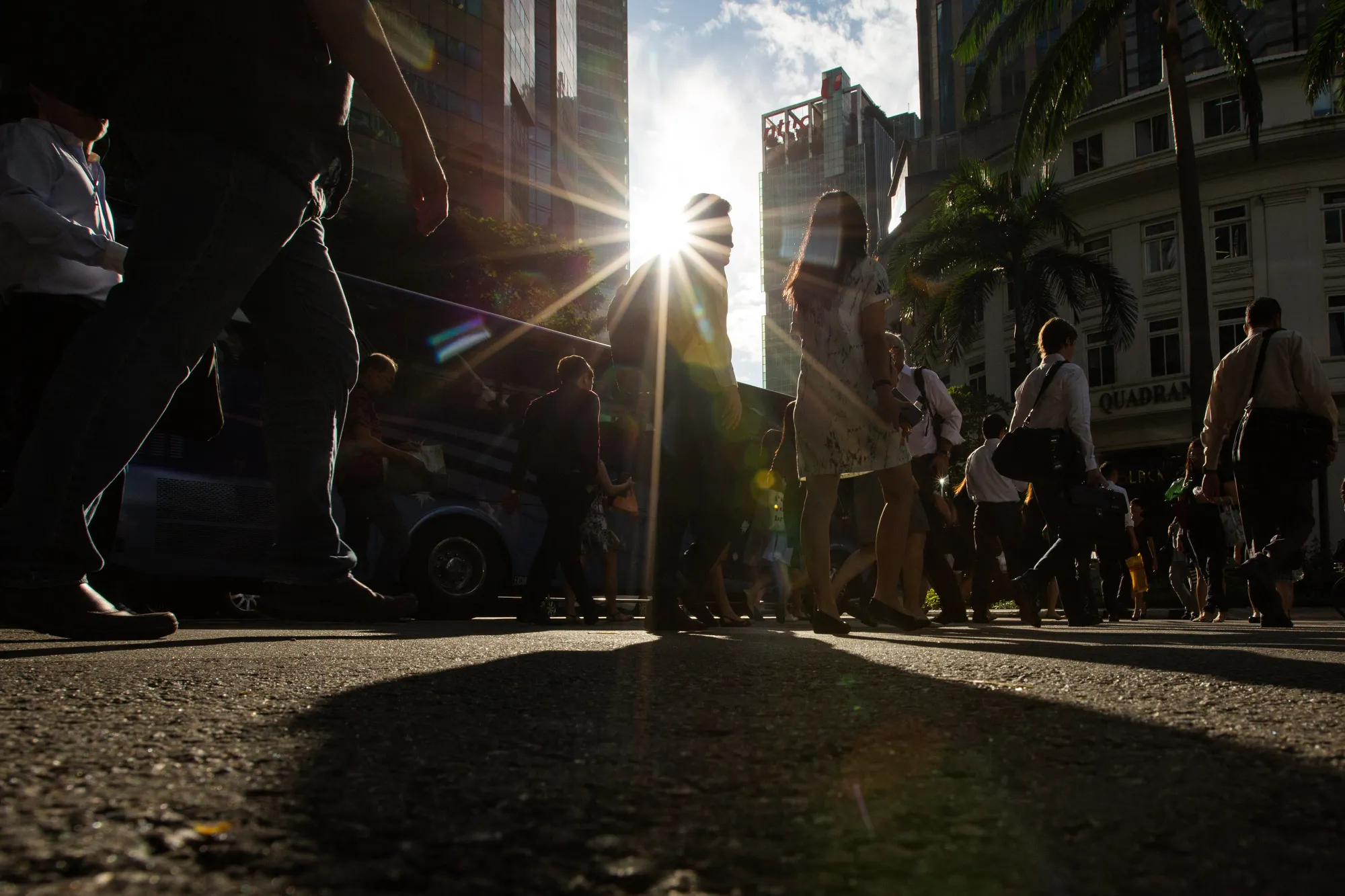 Morning commuters cross a road in the central business district of Singapore, on Wednesday, Sept. 14, 2016.