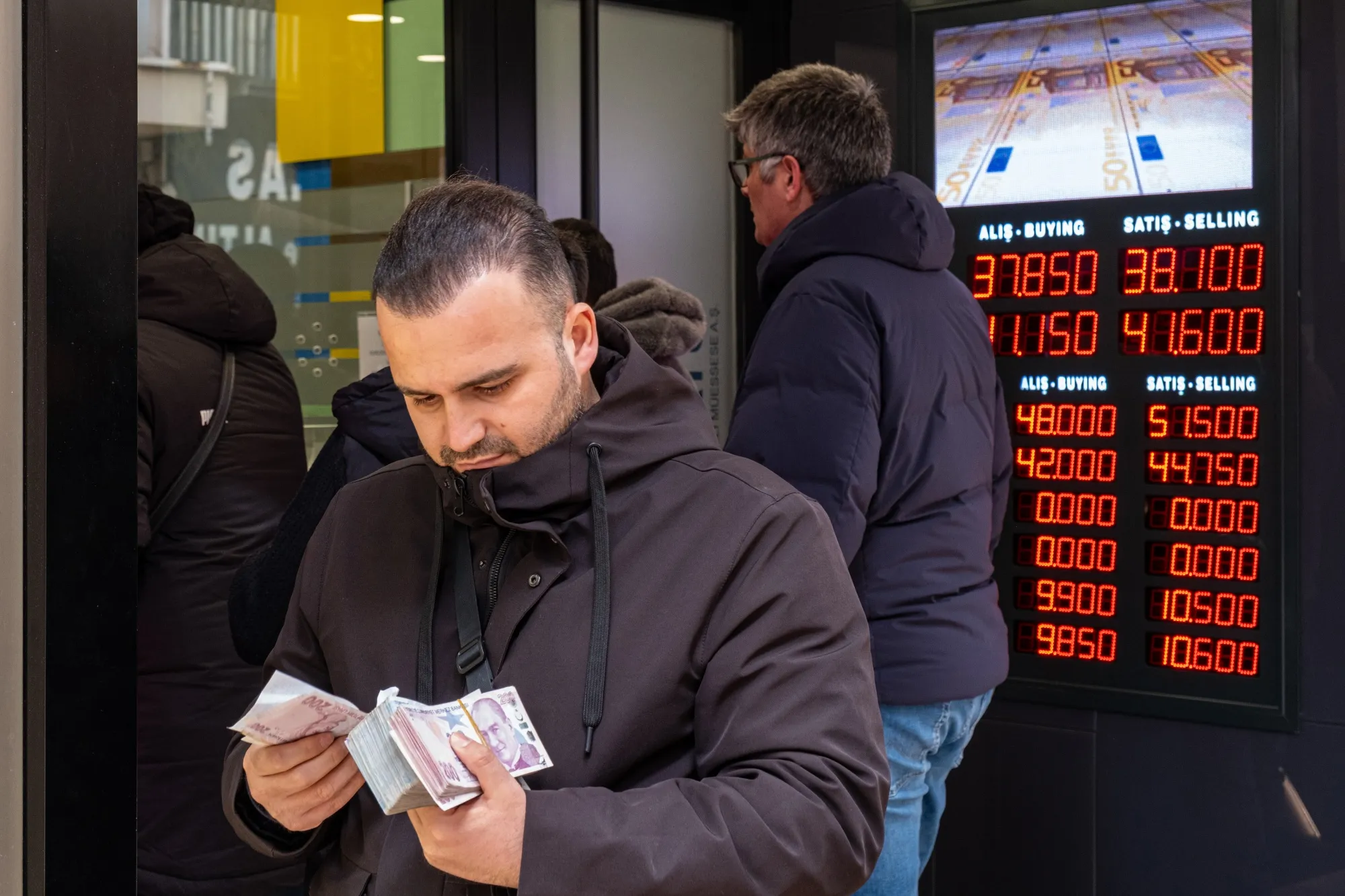 A customer with Turkish lira currency bank notes at a foreign currency exchange bureau in Istanbul.