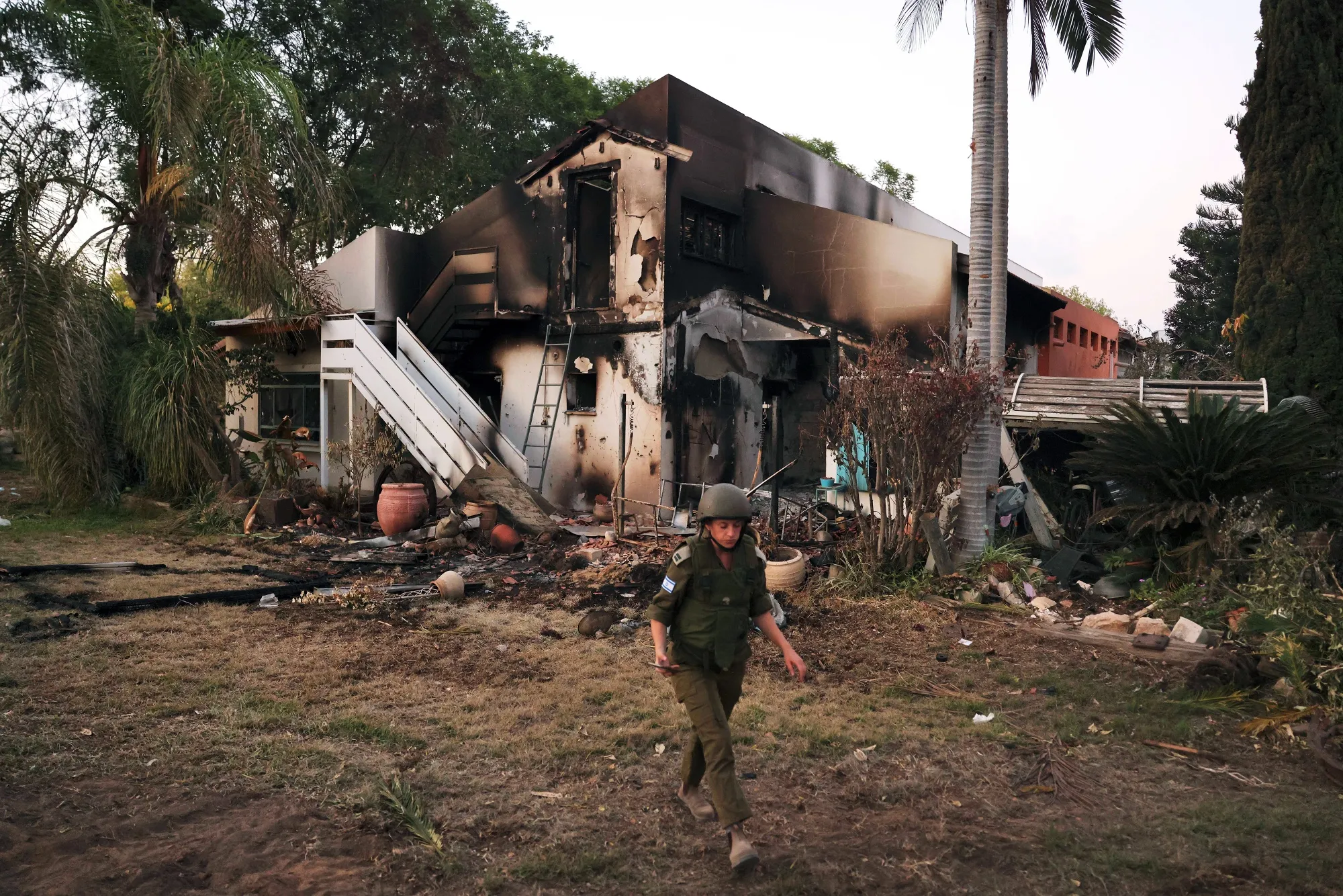 An Israeli soldier walks past a destroyed house in Be'eri, Kibbutz, Israel, on Wednesday.