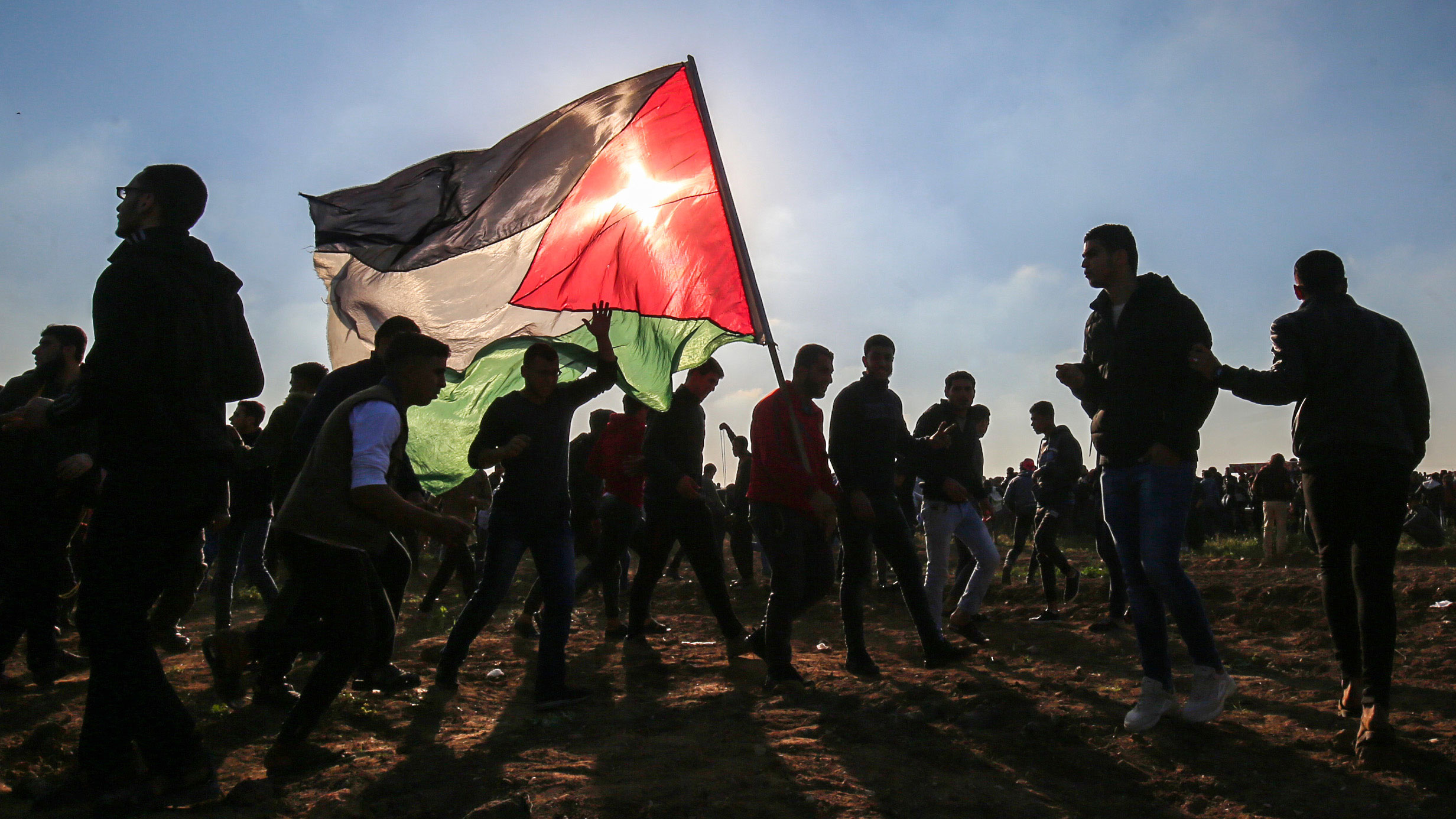 Palestinian&nbsp;protesters march with a Palestinian flag during a demonstration at the border fence with Israel in Gaza&nbsp;on March 22.