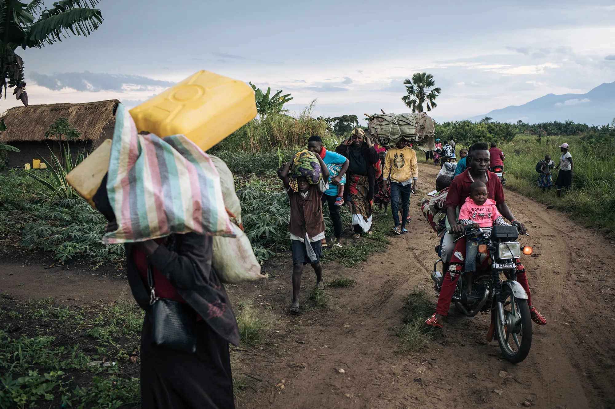 Displaced people carrying their belongings flee the scene of an attack&nbsp;in the Halungupa village, near Beni on Feb.&nbsp;18.