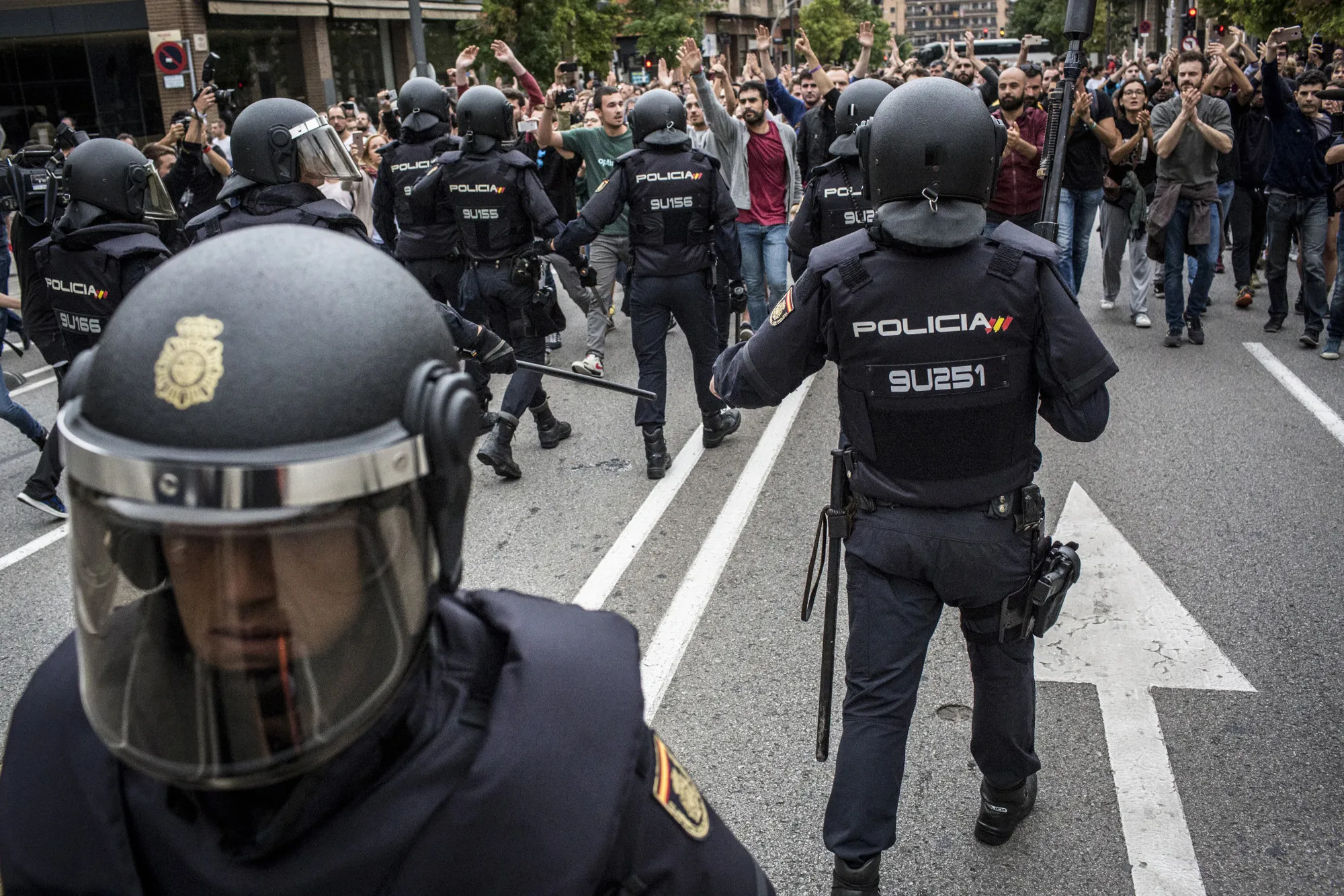 Spanish national police officers wearing riot gear confront pro Catalan referendum supporters in Sabadell, Spain, on Sunday, Oct. 1.