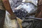 Workers load coal into a sack in Mumbai, India.