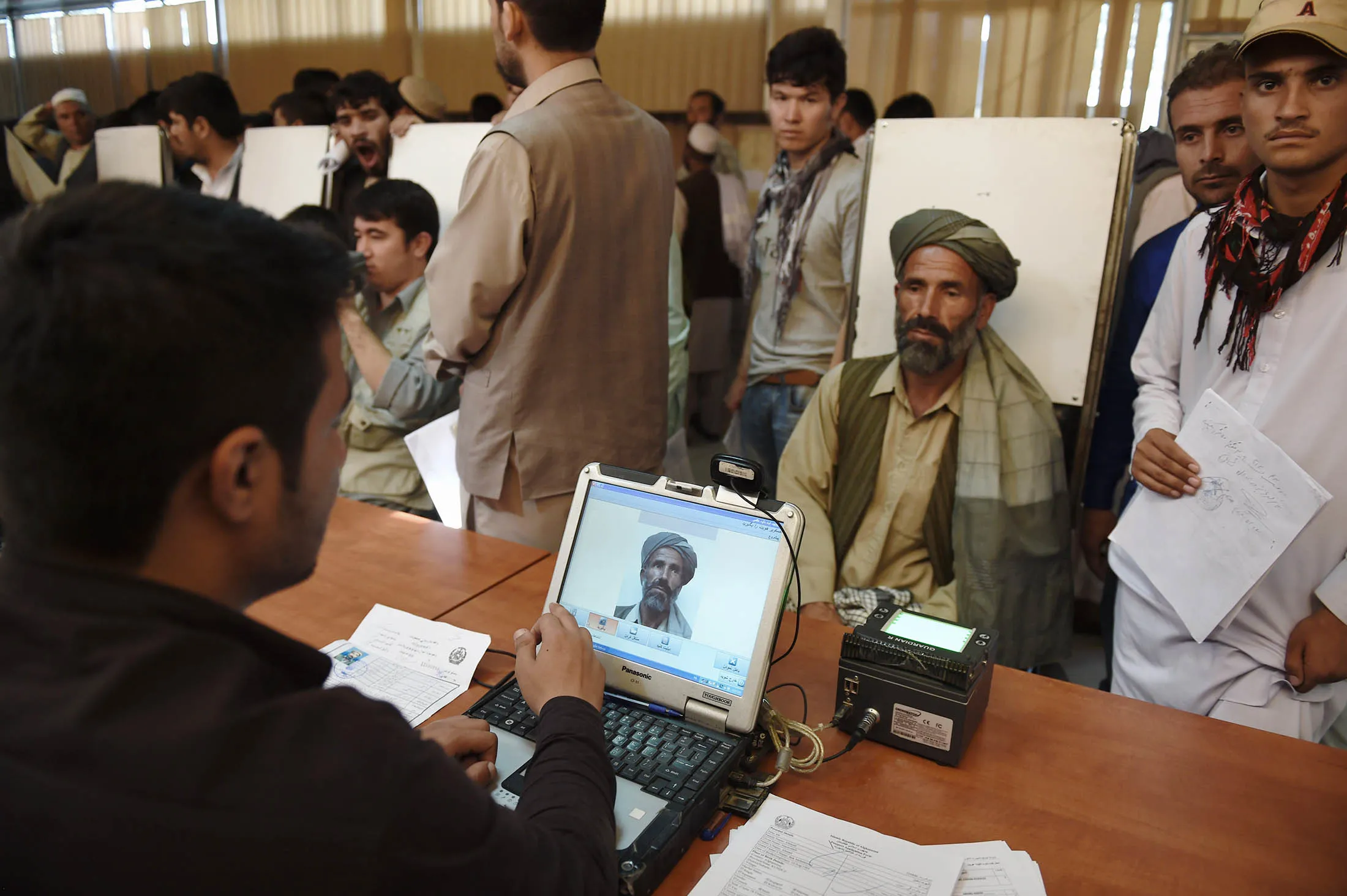 An Afghan man has his photograph taken his passport at the passport office in Kabul.

