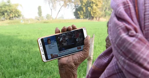An Indian farmer watches the national budget speech on his smartphone.