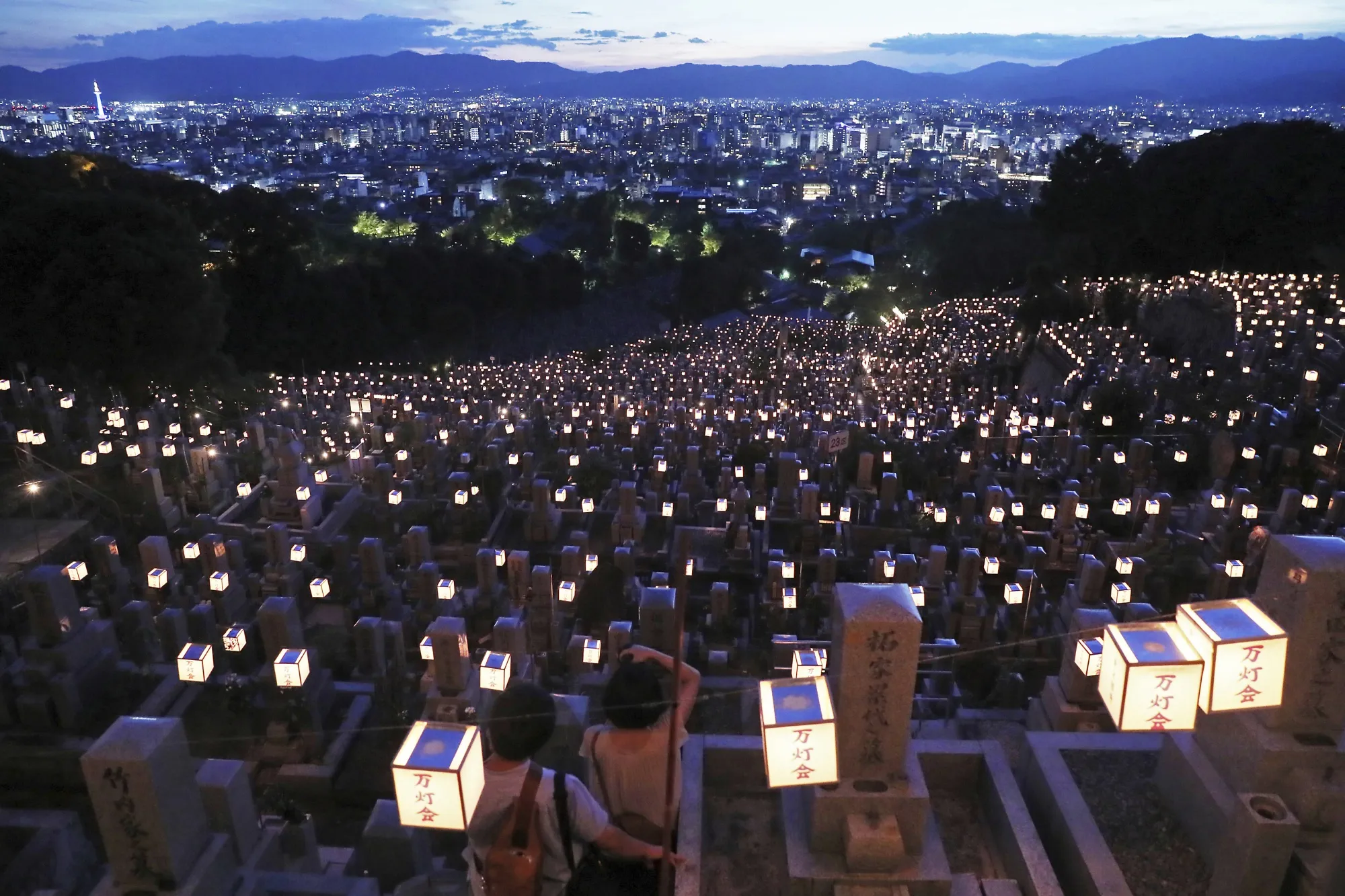 Visitors pray for their ancestors at a lantern-lit Obn cemetery in Kyoto in 2018.