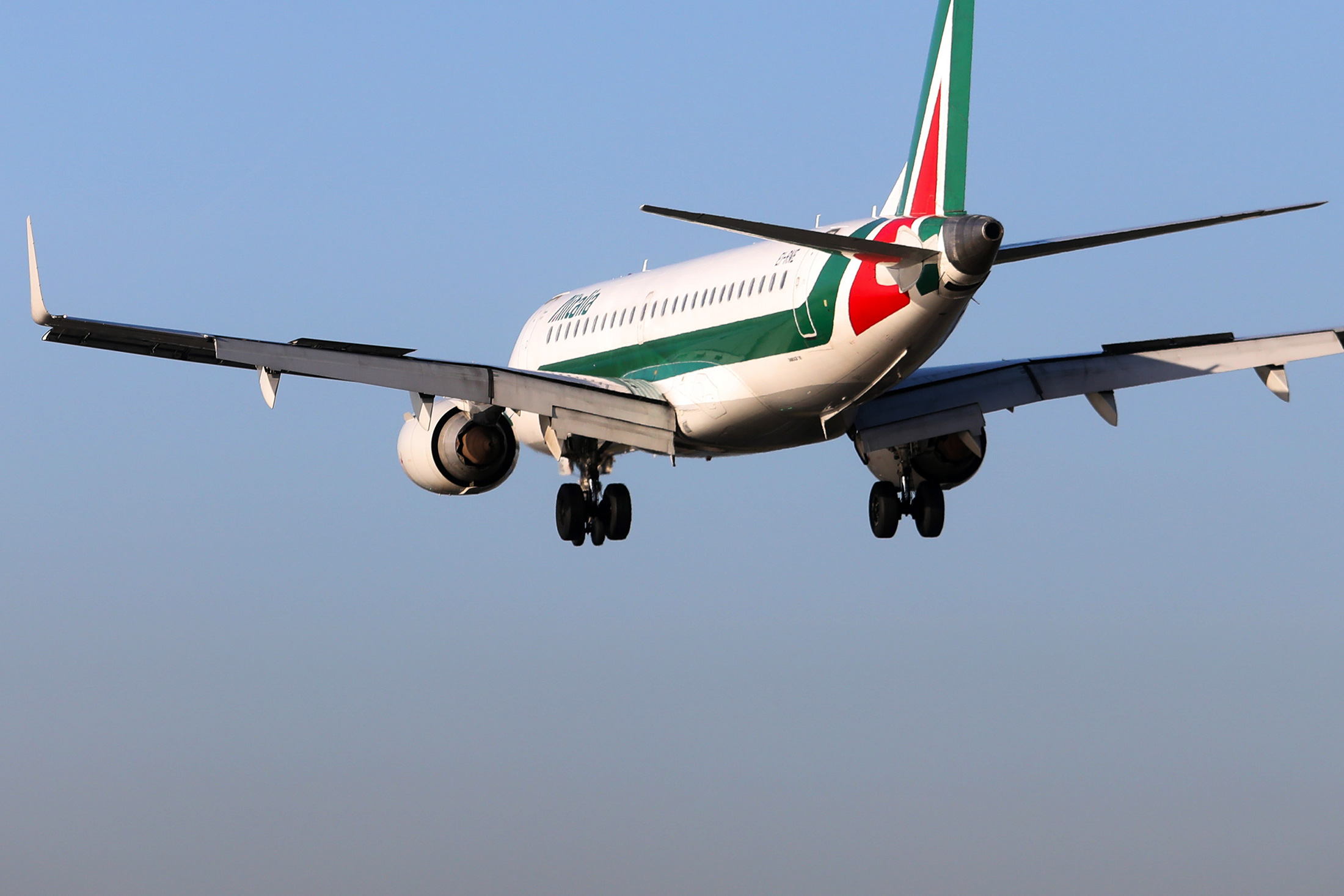 A bird flies past an Embraer passenger aircraft, operated by Alitalia SpA, as it prepares to land at London City Airport in London, U.K., on Thursday, Jan. 5, 2017. Alitalia shareholders approved Etihad Airways PJSC investment of up to $231m, Etihad became Alitalia's largest shareholder in 2014 as part of the Persian Gulf carrier's attempt to gain a European foothold by strengthening struggling carriers in the region.

