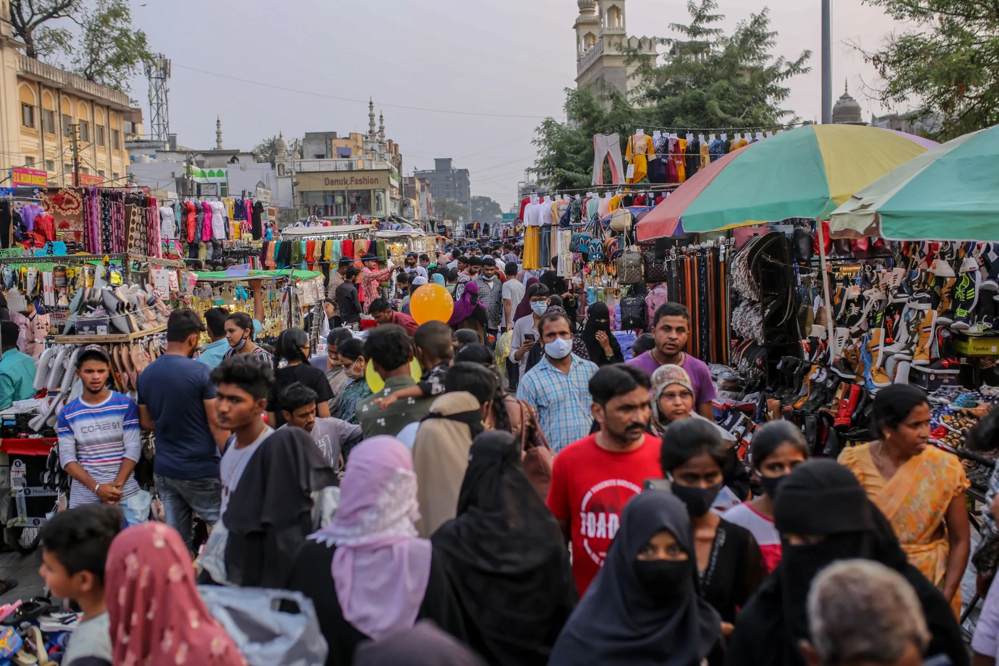 Shoppers walk through a market in the Charminar area in Hyderabad, India.