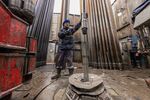A worker guides drilling pipes at an oil, gas and condensate field in the Lensk district of the Sakha Republic, Russia.