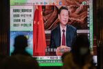 A news report on Chinese President Xi Jinping's New Year's Eve speech is shown on a public screen in Hong Kong, China, on Thursday, Dec. 31, 2020.