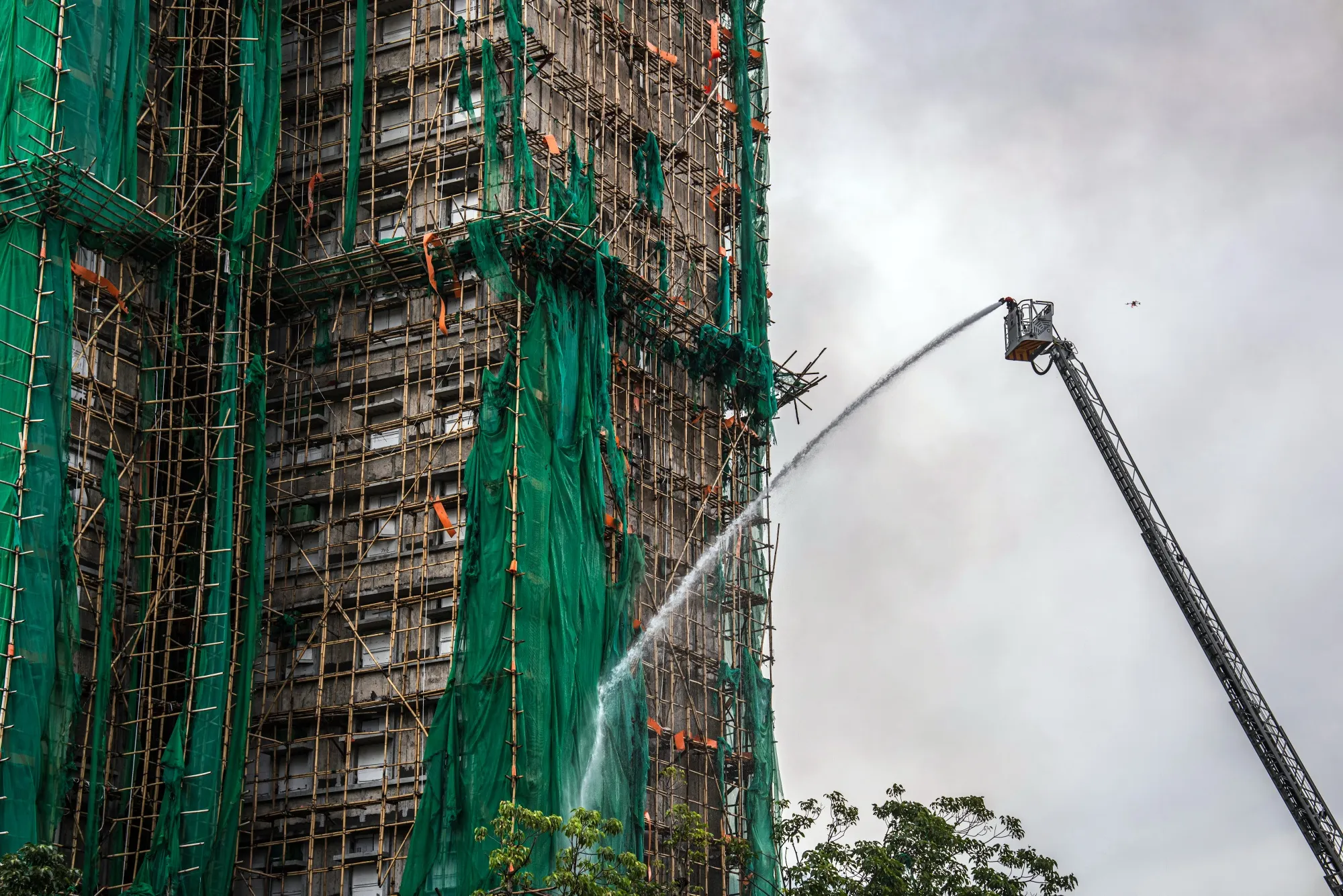 Firefighters hose down a smoldering building at Wang Fuk Court in Hong Kong.