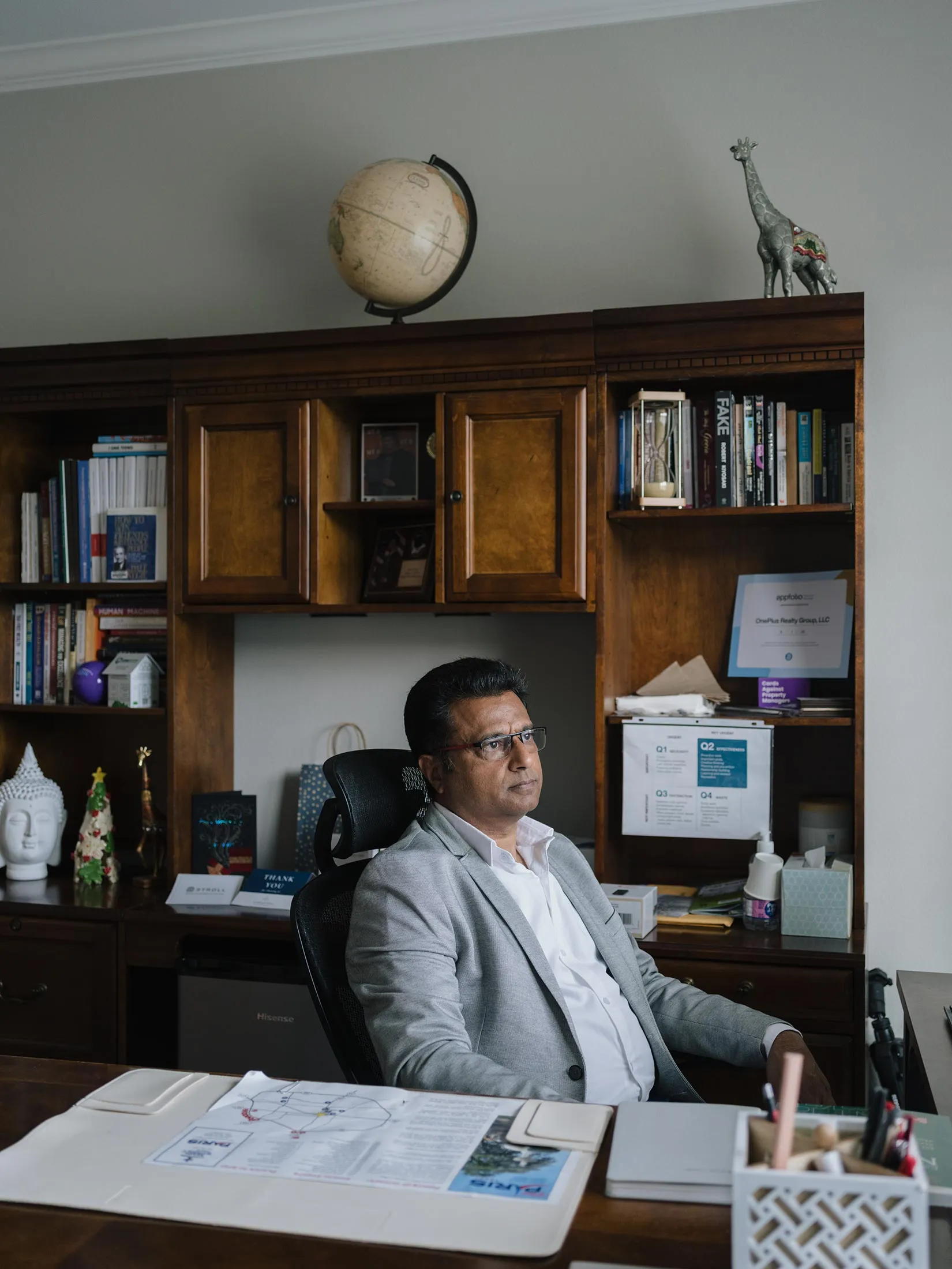 Neeraj Gupta sits at his desk in his real estate office in Frisco, Texas.