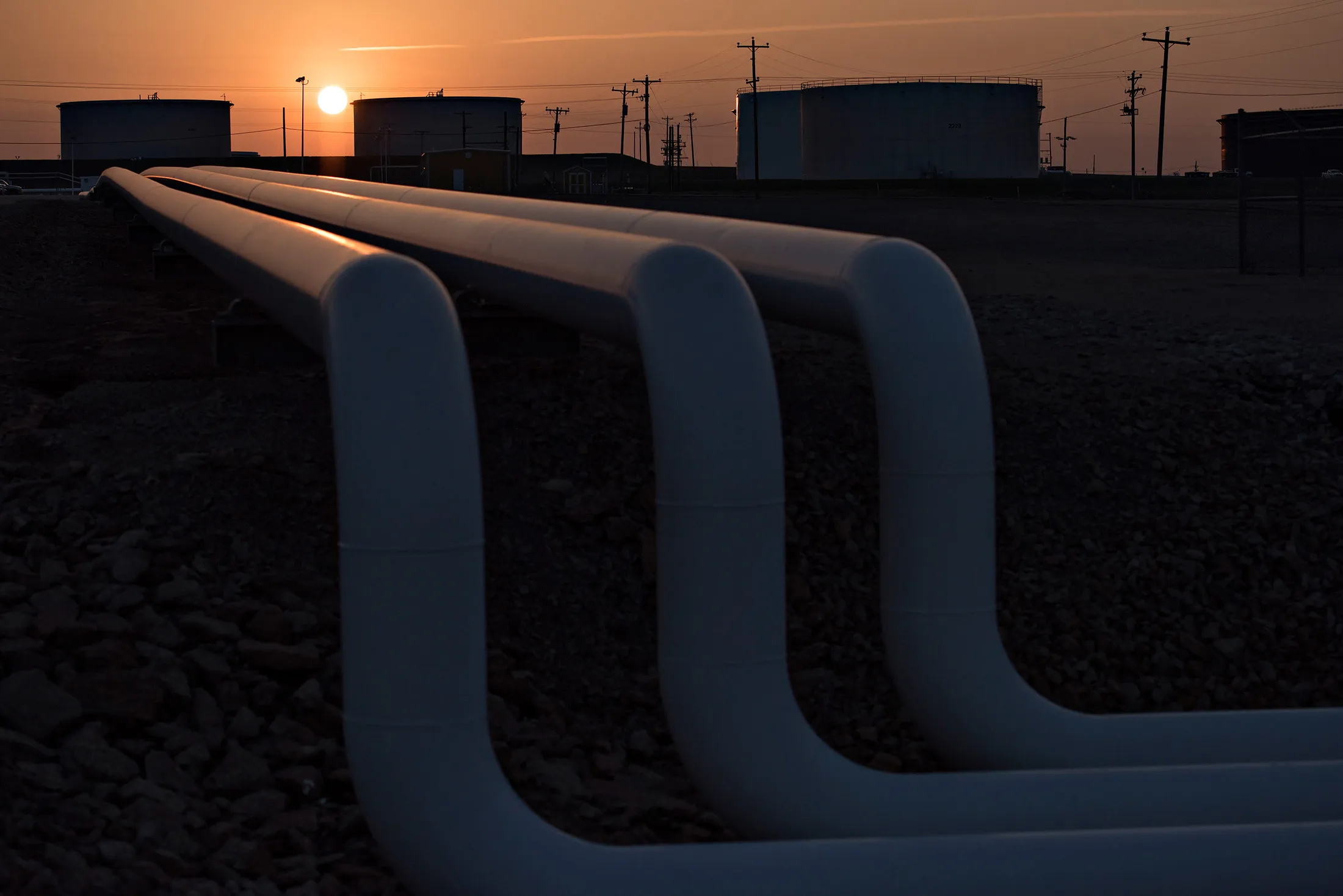 The sun rises beyond oil storage tanks at the Enbridge Inc. Cushing storage terminal in Cushing, Oklahoma, U.S., on Wednesday, March 25, 2015. The fastest oil-inventory growth on record at the main U.S. hub may be about to end, easing concern that storage limits will be strained.
