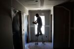 Raul Rios, wearing a pair of stilts, applies joint compound to the seams of drywall at a house under construction in Raleigh, N.C.