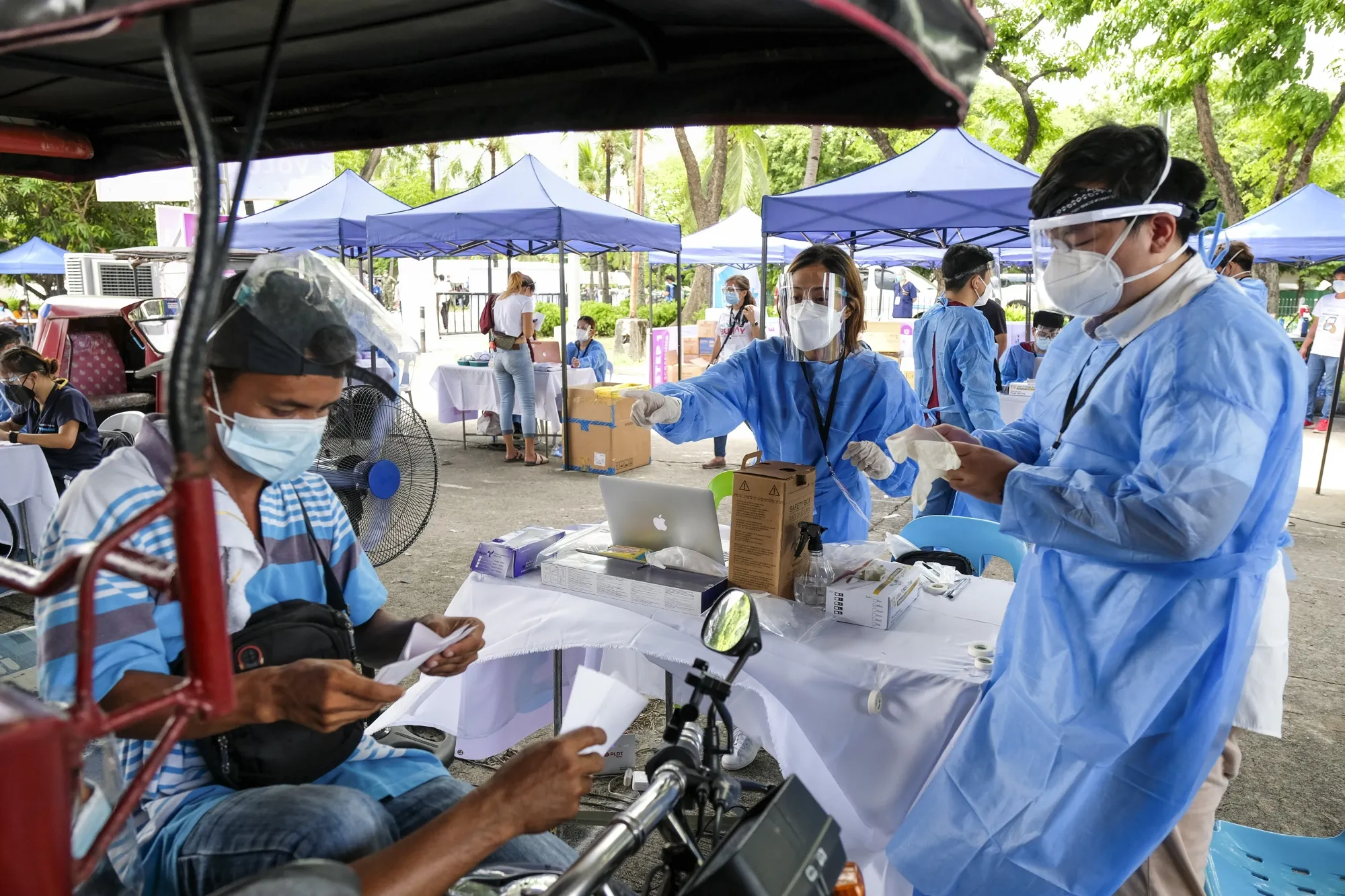 A motorcycle taxi driver undergoes screening at a Covid-19 drive-thru vaccination site in Manila, on June 22.
