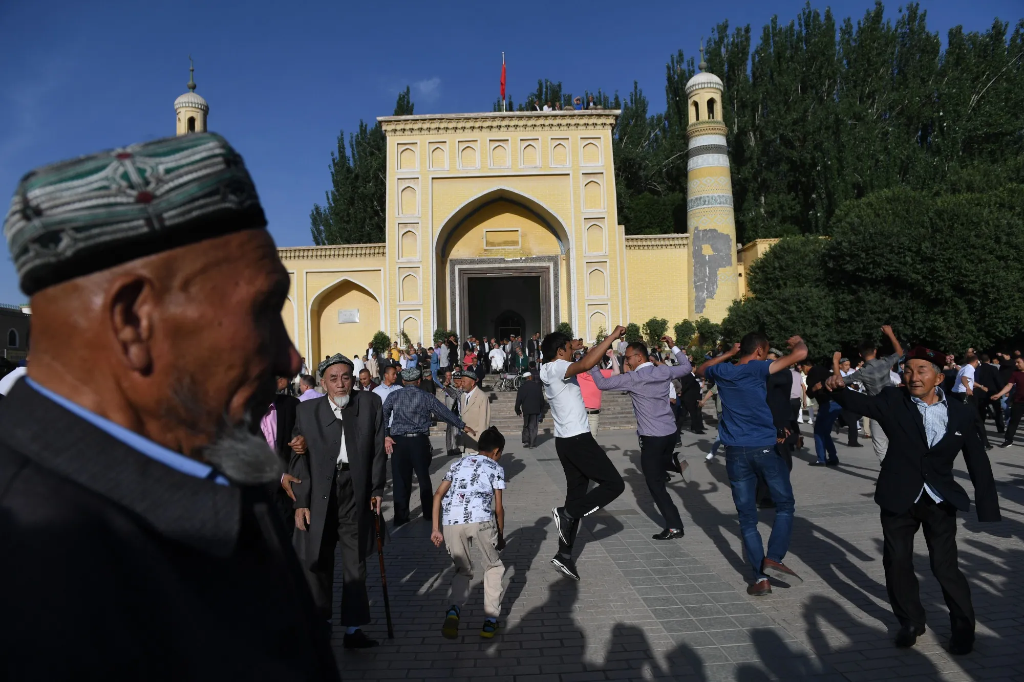Uighur men dancing after Eid al-Fitr prayers, marking the end of Ramadan, outside the Id Kah mosque in Kashgar, in China's western Xinjiang region.&nbsp;