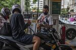 A worker refuels a motorcycle at a gas station in Sao Paulo, Brazil.