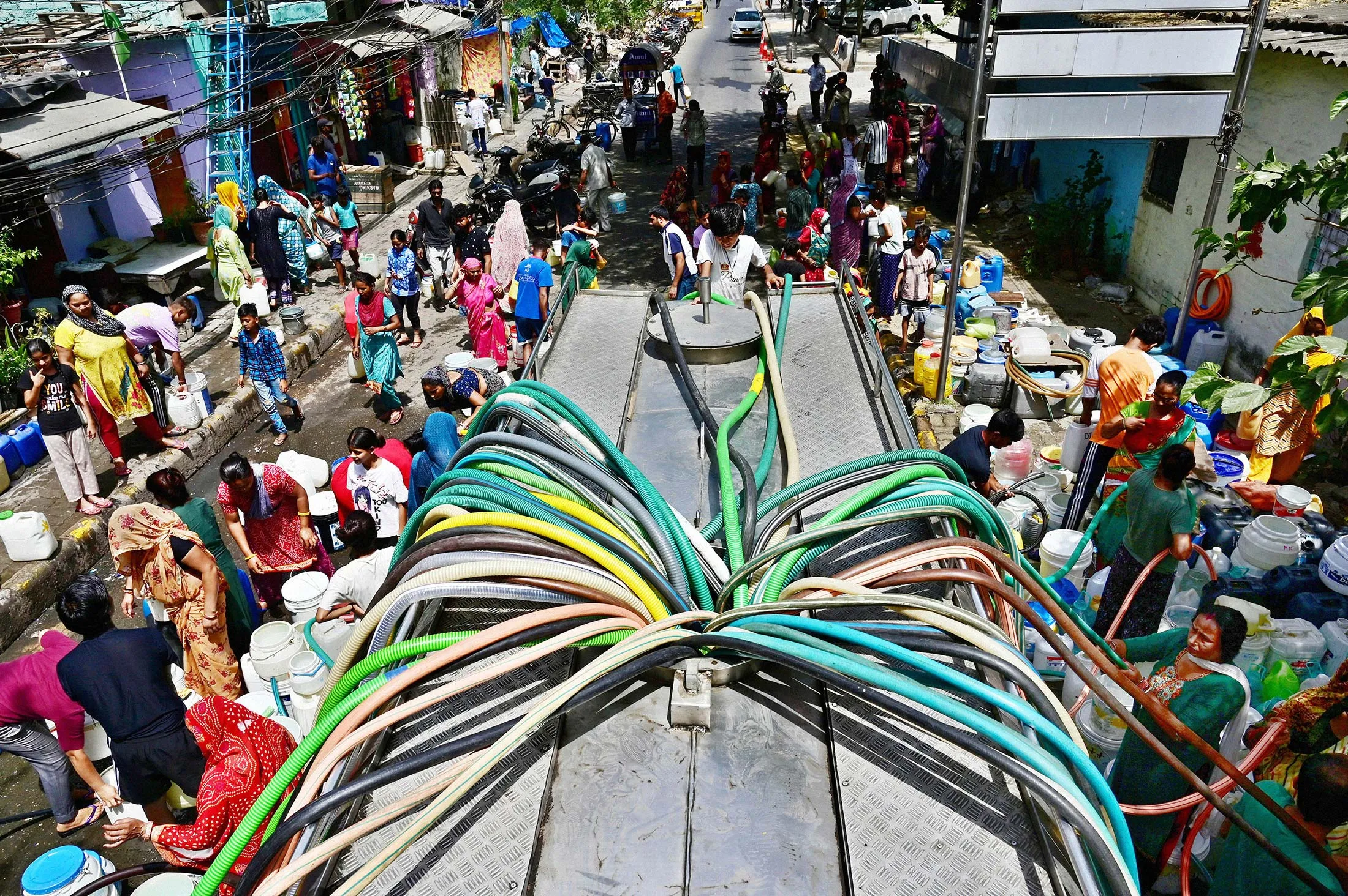Residents of JJ Cluster Vivekanand Colony in the Chanakyapuri neighborhood of New Delhi fill up water from a tanker.