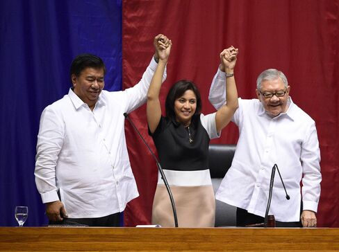 Philippine Senate president Frank Drilon and House speaker Feliciano Belmonte raise the hands of vice president-elect Leni Robredo during her proclamation as vice president at the Session Hall of the House of Representatives in Manila on Monday.