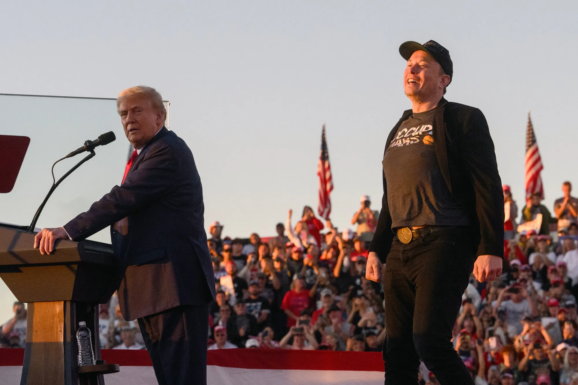Elon Musk, chief executive officer of Tesla Inc., right, joins former US President Donald Trump on stage during a campaign event at the Butler Farm Show in Butler, Pennsylvania, US, on Saturday, Oct. 5, 2024.