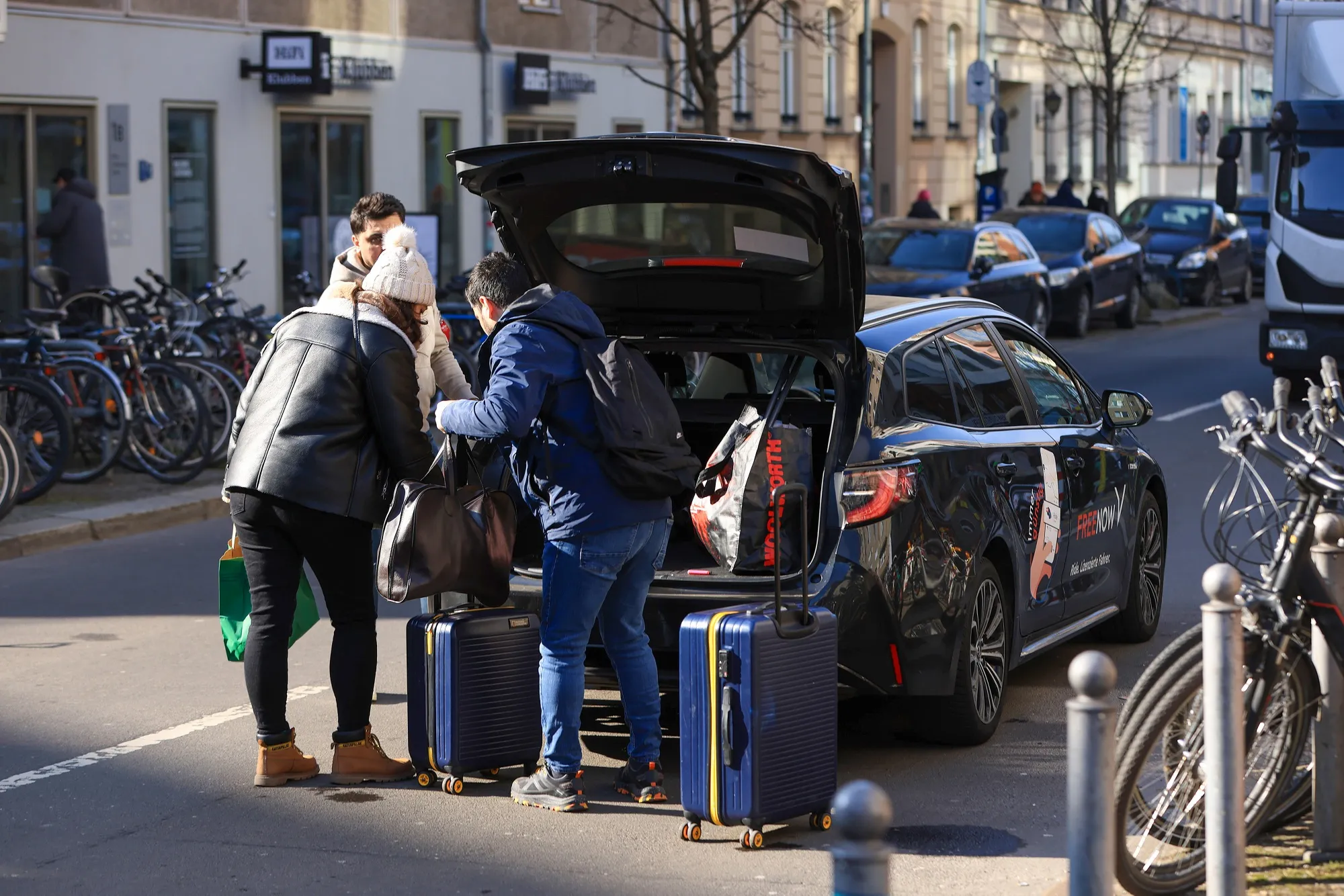 Passengers load&nbsp;luggage into a taxi, operated by FreeNow, in Berlin.