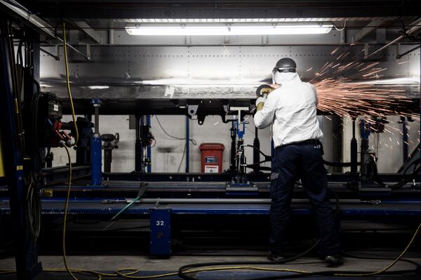 A worker fabricates a part for use in a rail carriage on the production line at a Siemens railway plant.