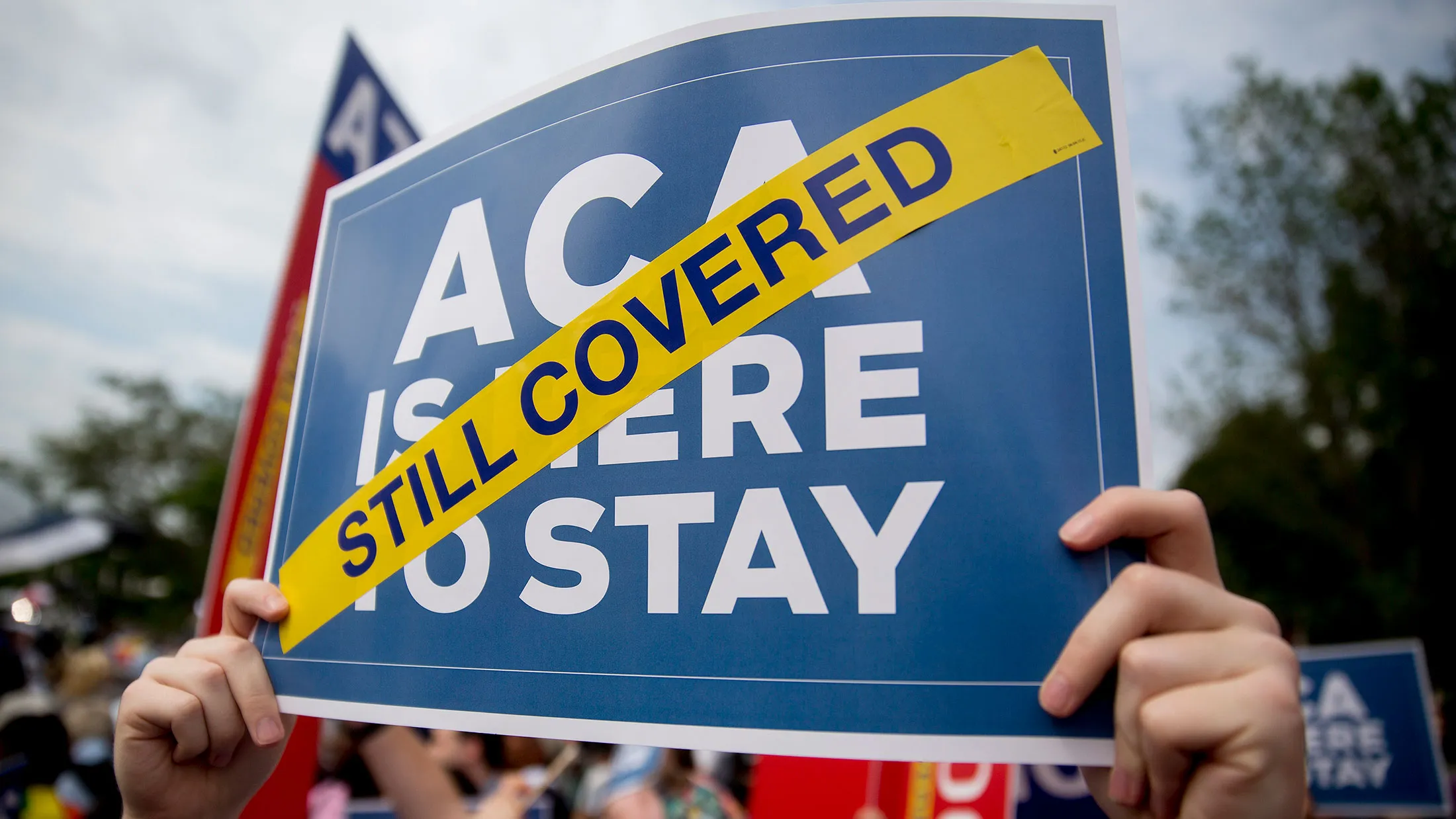 A demonstrator in support of President Barack Obama's health-care law holds up a sign outside the Supreme Court in Washington on June 25, 2015.
