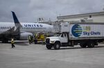 A passenger aircraft operated by United Airlines Holdings Inc., right, and a Sky Chefs Inc. truck at Miami International Airport in Miami, Florida, U.S., on Wednesday, June 16, 2021.