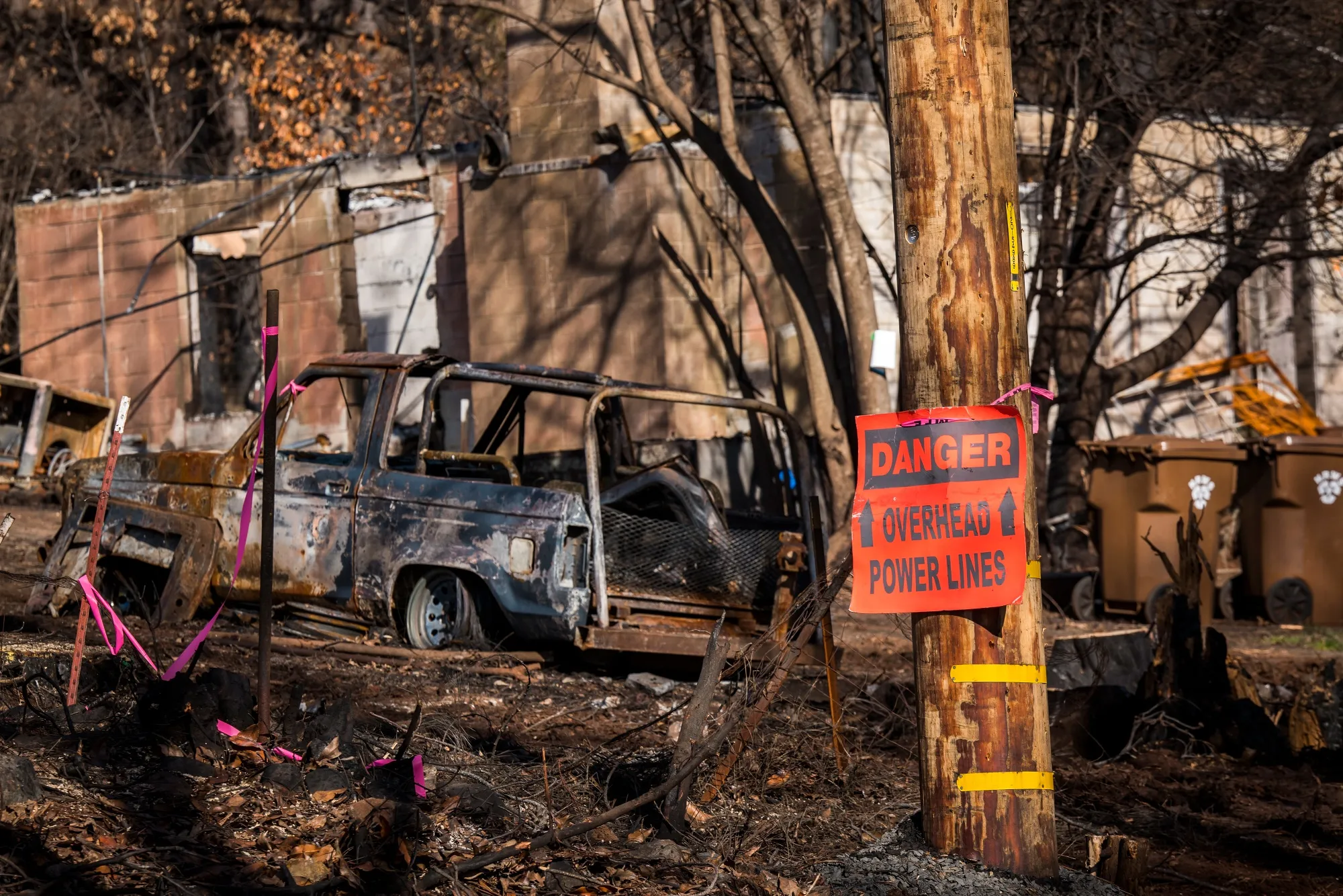 Signage warning of power lines overhead is seen next to a burned-out vehicle in Paradise, California,&nbsp;on&nbsp;Jan. 22, 2019.&nbsp;