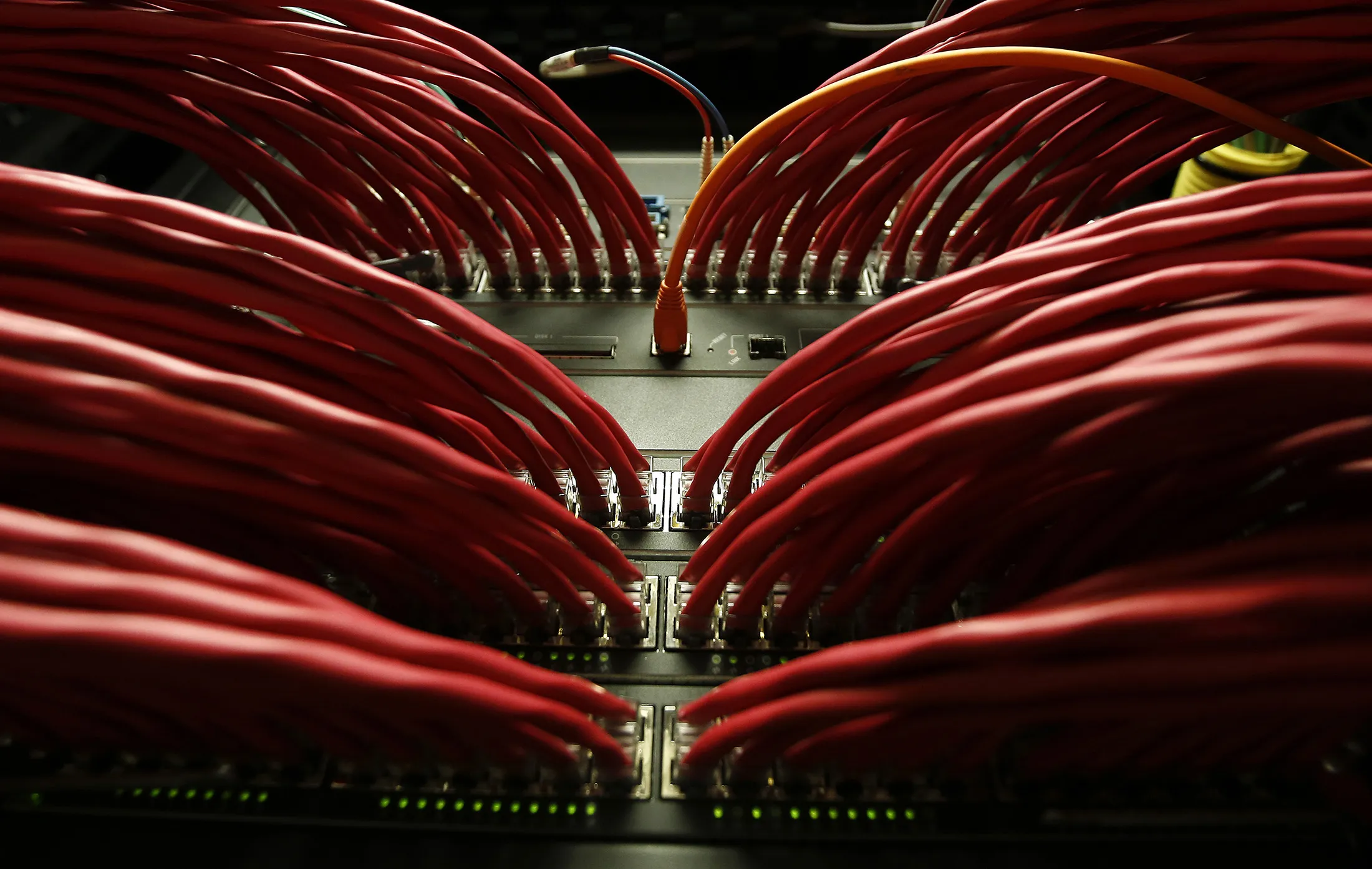 Rows of colored high end data cables are seen feeding into racks of computer servers inside a comms room at an office in London, U.K., on Tuesday, Dec. 23, 2014.
