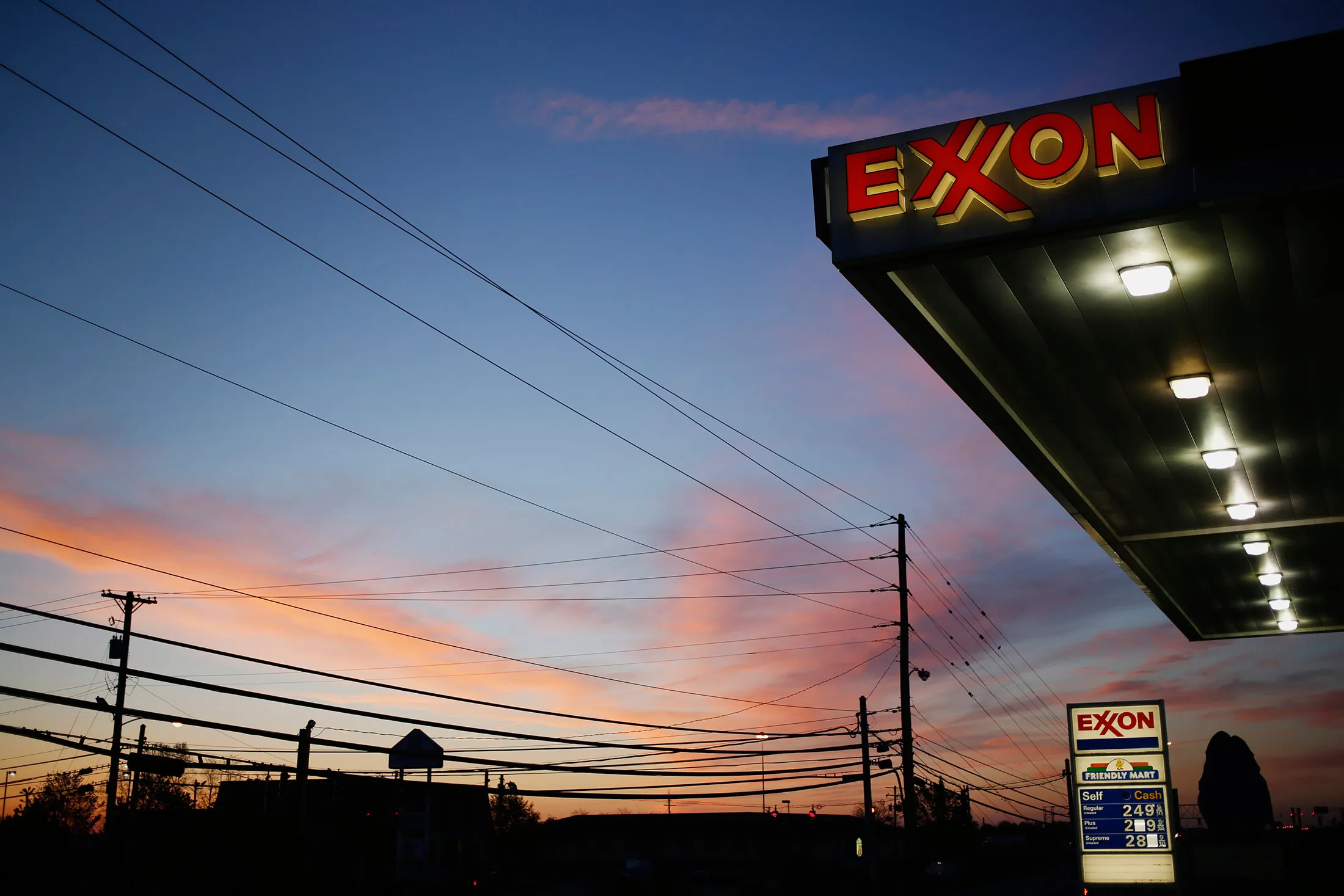 ExxonMobil Corp. signage glows at a gas station in Richmond, Kentucky, at dawn on April 29, 2015.
