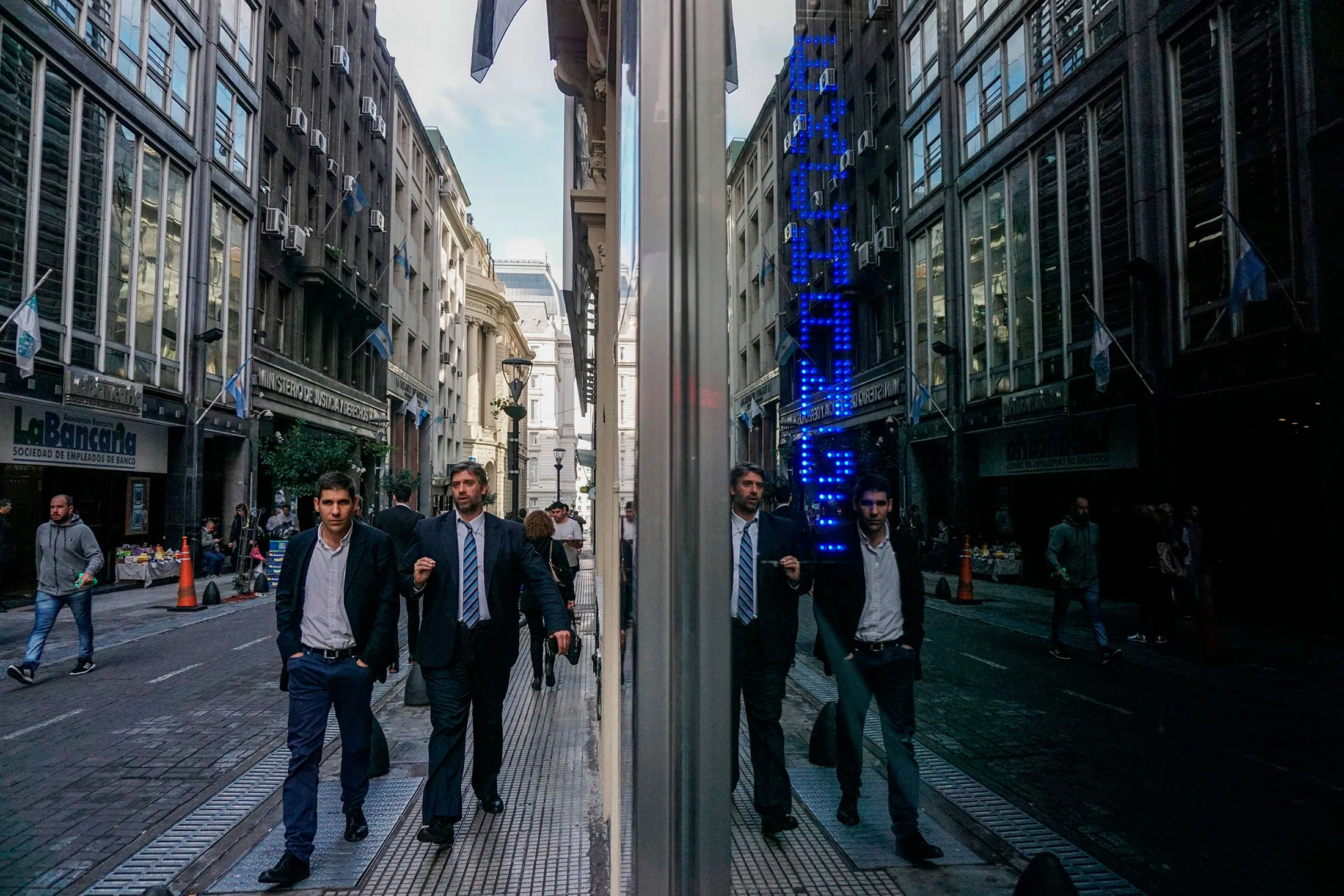 Men walk by an exchange bureau in the financial district of Buenos Aires.