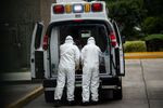 Red Cross' paramedics prepare to carry a patient suspected of being infected with the novel coronavirus from an ambulance in Mexico City, on May 20.